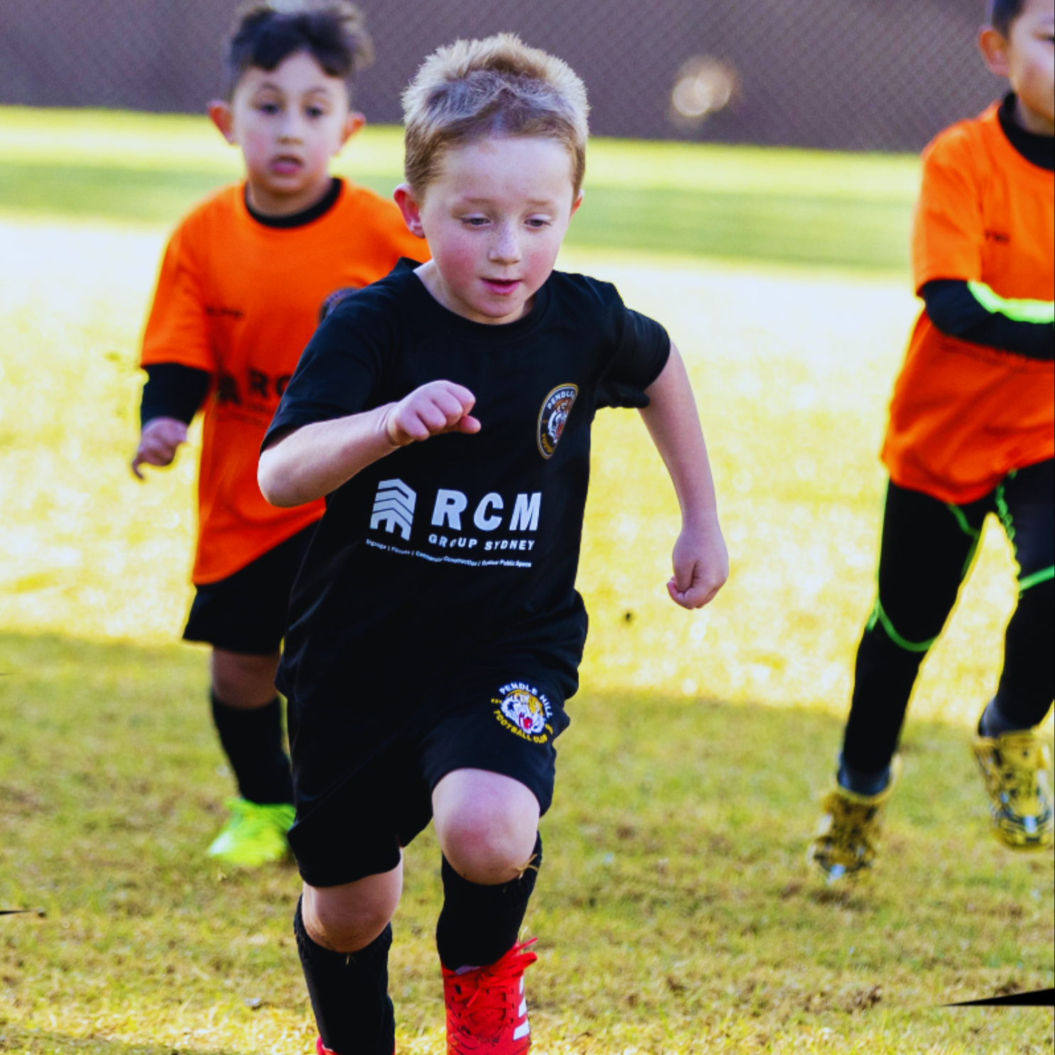 Young players running to a soccer ball playing MiniRoos football program activity to focus on their personal development.