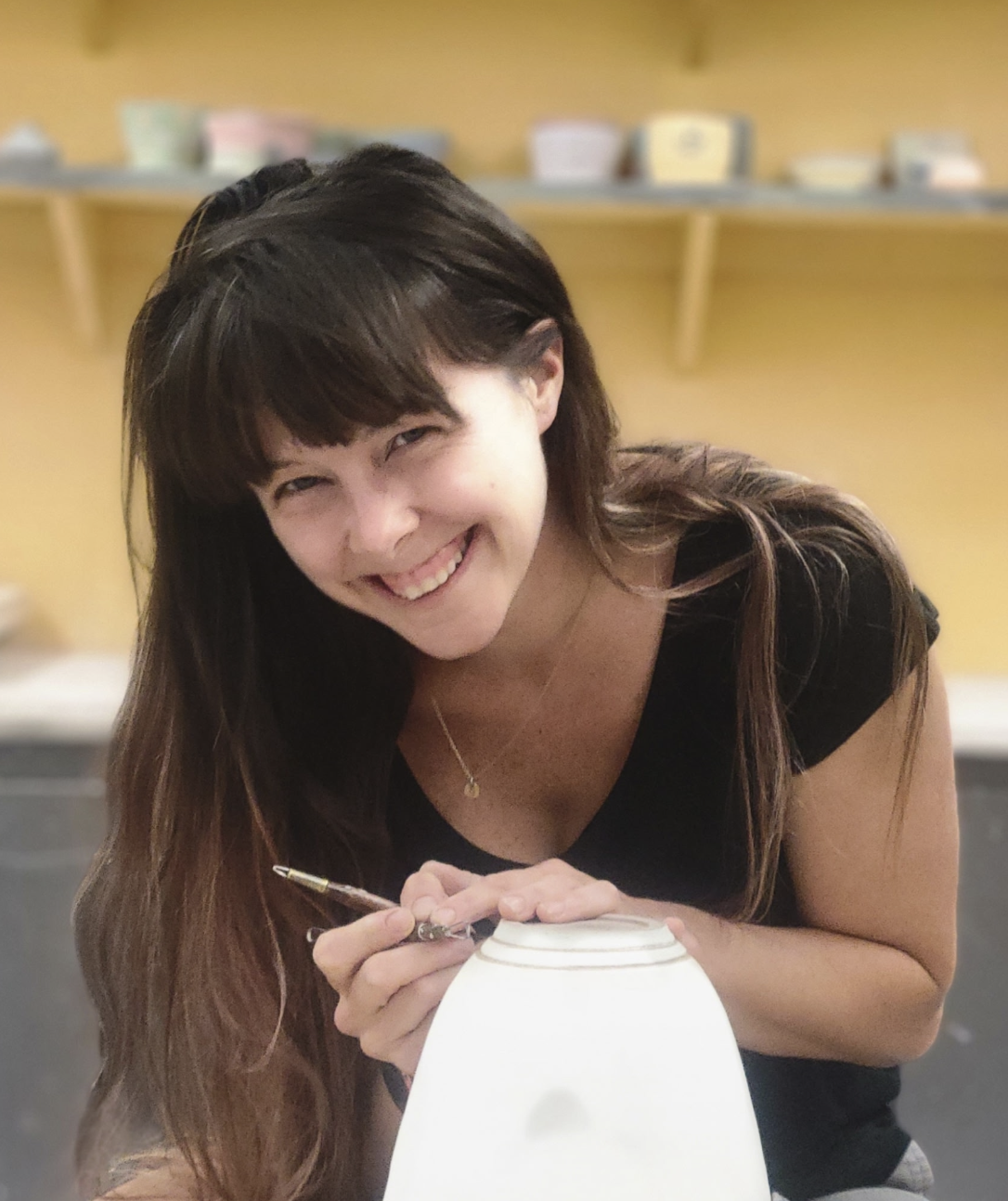 Smiling woman trimming ceramic pot