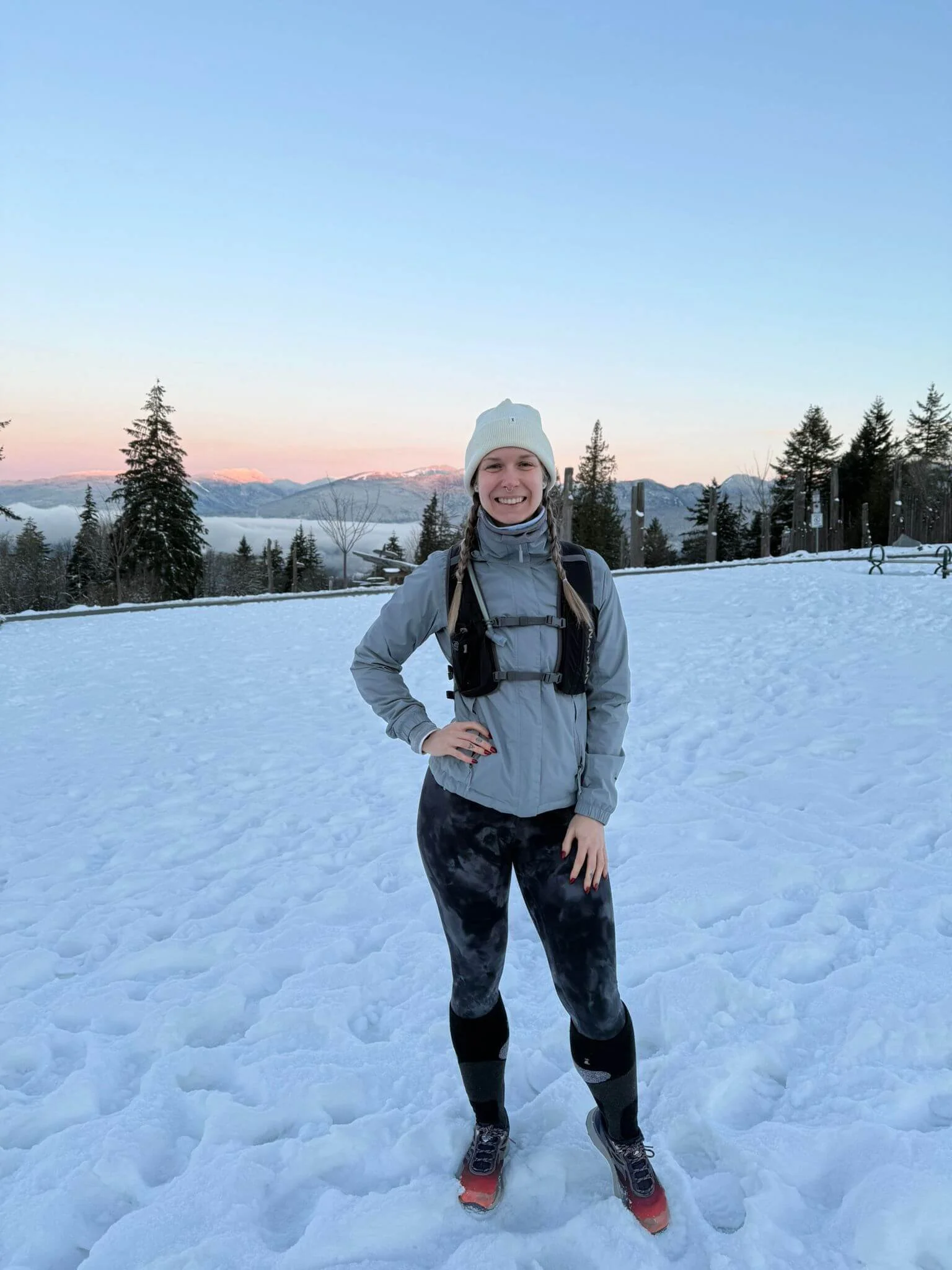 a female runner is posing on the mountains before her workout