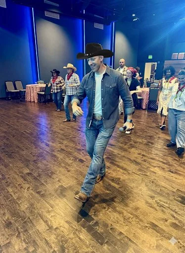 Corporate group participating in interactive country line dance lesson at a corporate conference