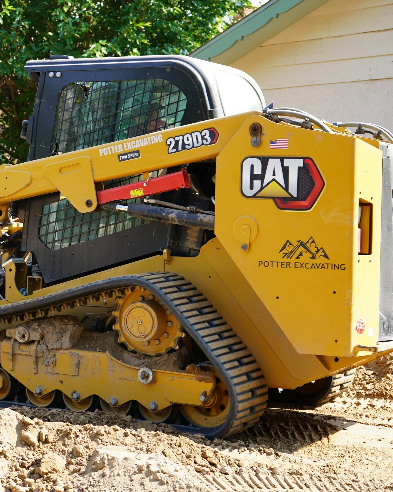 A bright yellow CAT excavator from Potter Excavating sits on-site, bucket resting on freshly moved earth. The machine stands out against the Southern Colorado landscape, ready for action—representing the power, precision, and reliability behind every