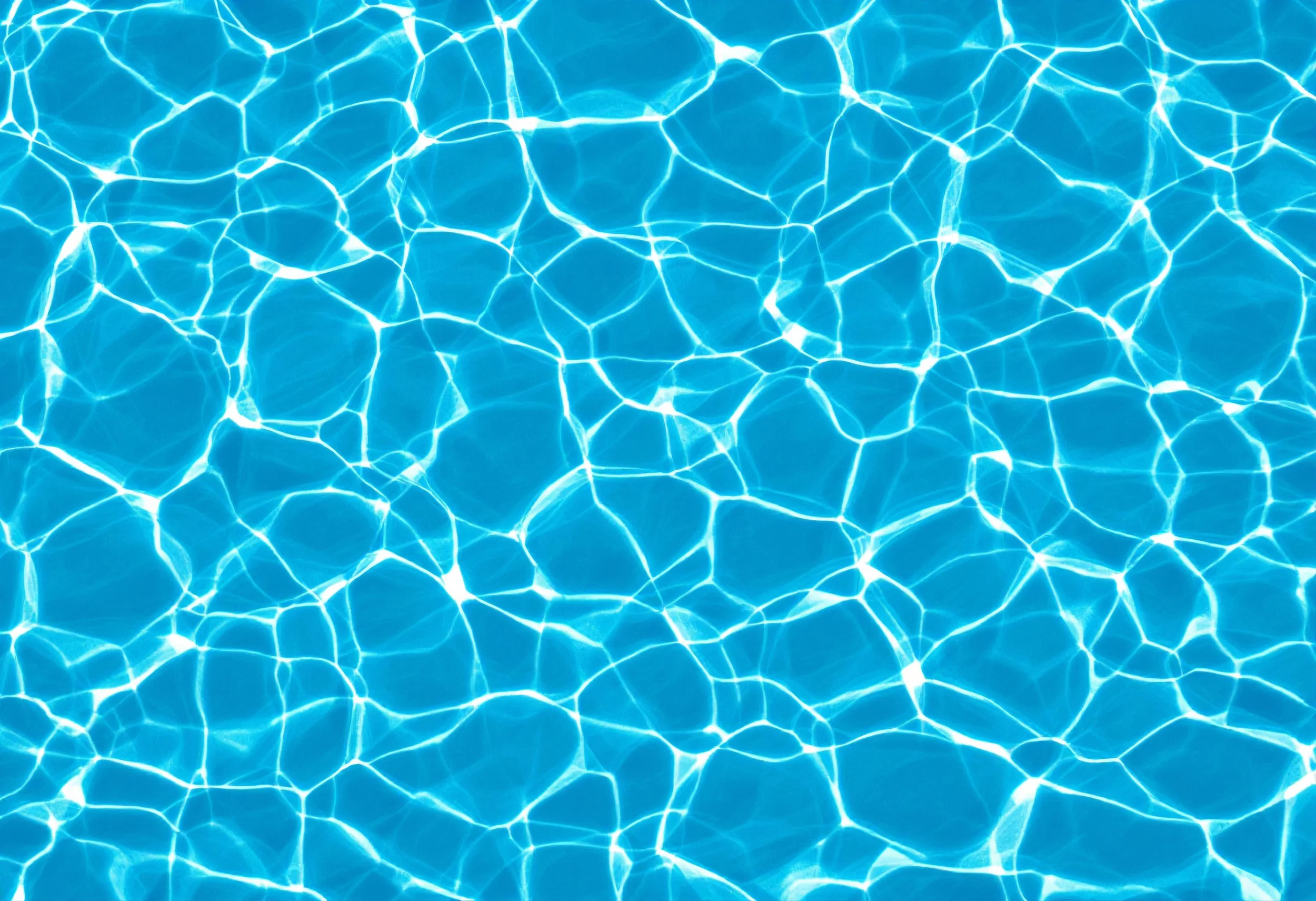 Blue swimming pool water texture with sunlight reflections creating a pattern of light and dark areas.