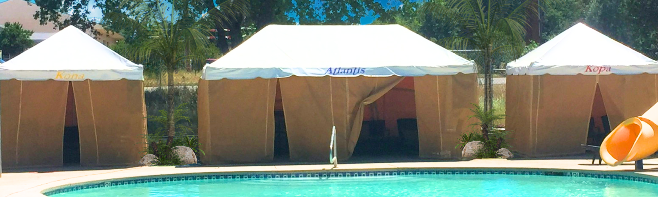 The image shows a VIP cabanas with a standard cabana on each side. The cabanas featured are located at the Activity Pool. The Cabana have white roofing and tan colored siding and entrances. Lush green foliage and trees line the background.