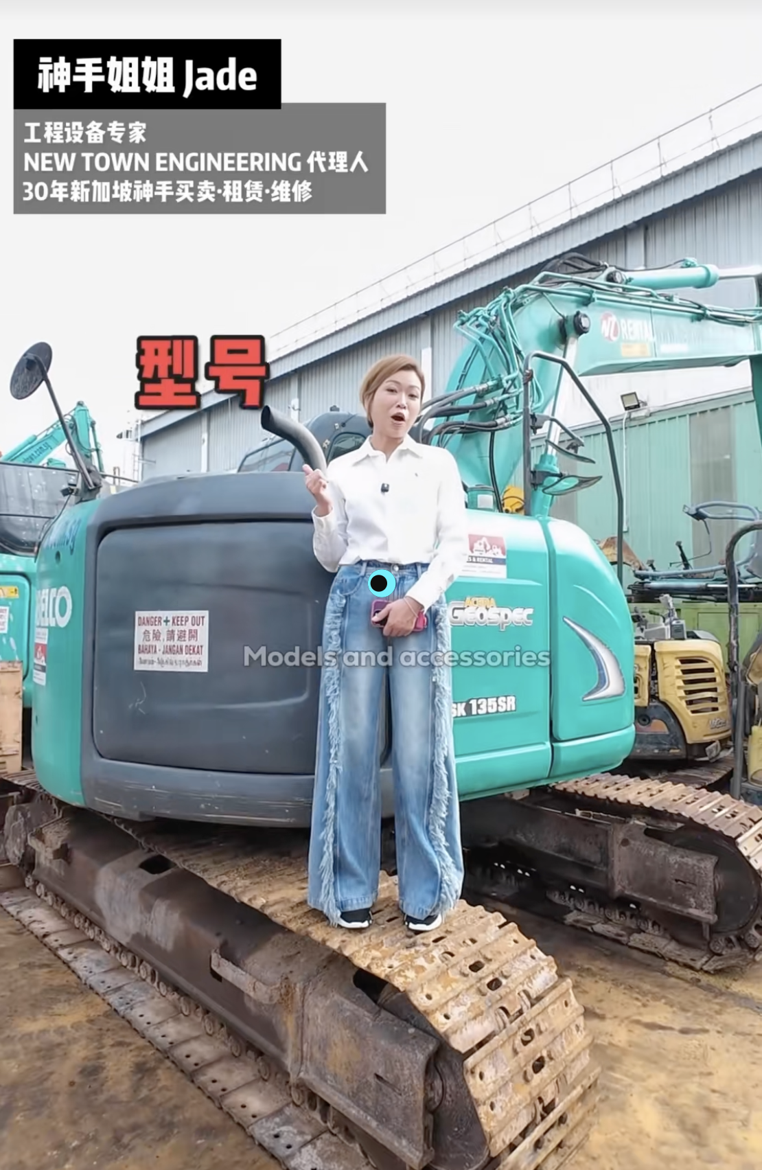 A woman standing on a construction excavator at a equipment yard, with text overlays in Korean and English and a warehouse building in the background.