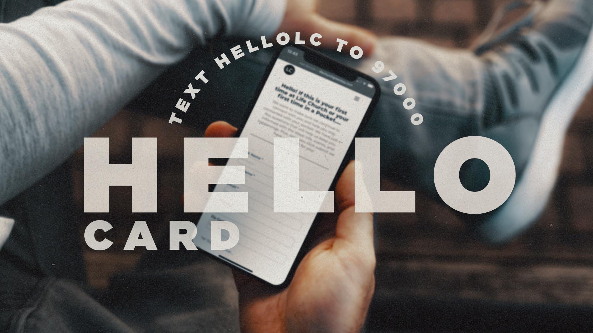Person holding smartphone displaying a card, with overlaying text saying 'Text hello to 97000'.