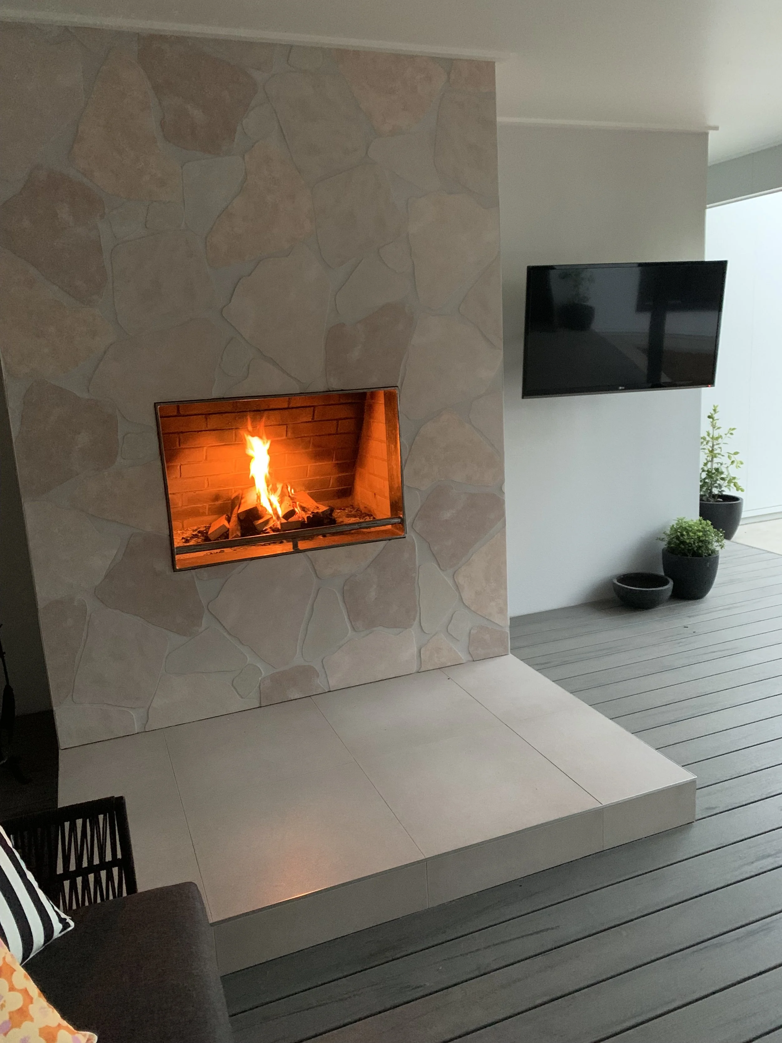 Outdoor Living Area – Wangaratta. A contemporary outdoor space with a low maintenance ModWood deck and crazy paving surrounding the fireplace, designed for relaxed entertaining.