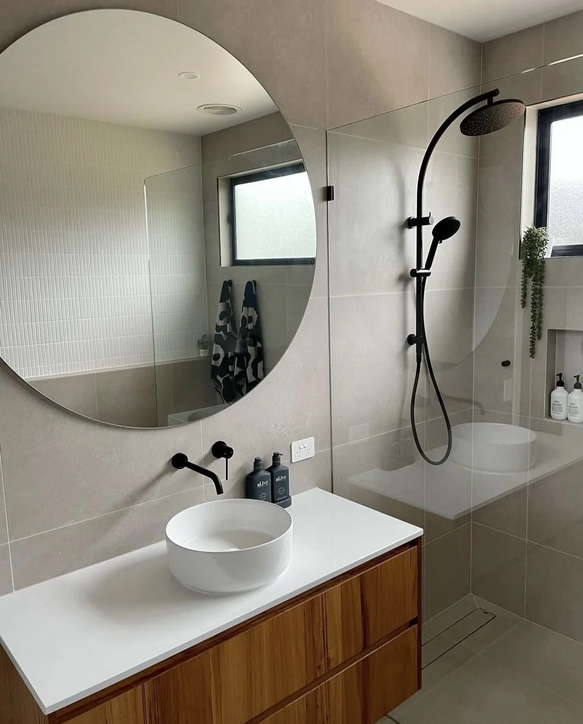 Bathroom Renovation – Wangaratta. A modern bathroom renovation featuring a custom blackbutt wall-hung vanity, Caesarstone benchtop, and full-height tiling, finished with a striking Kit Kat feature wall.