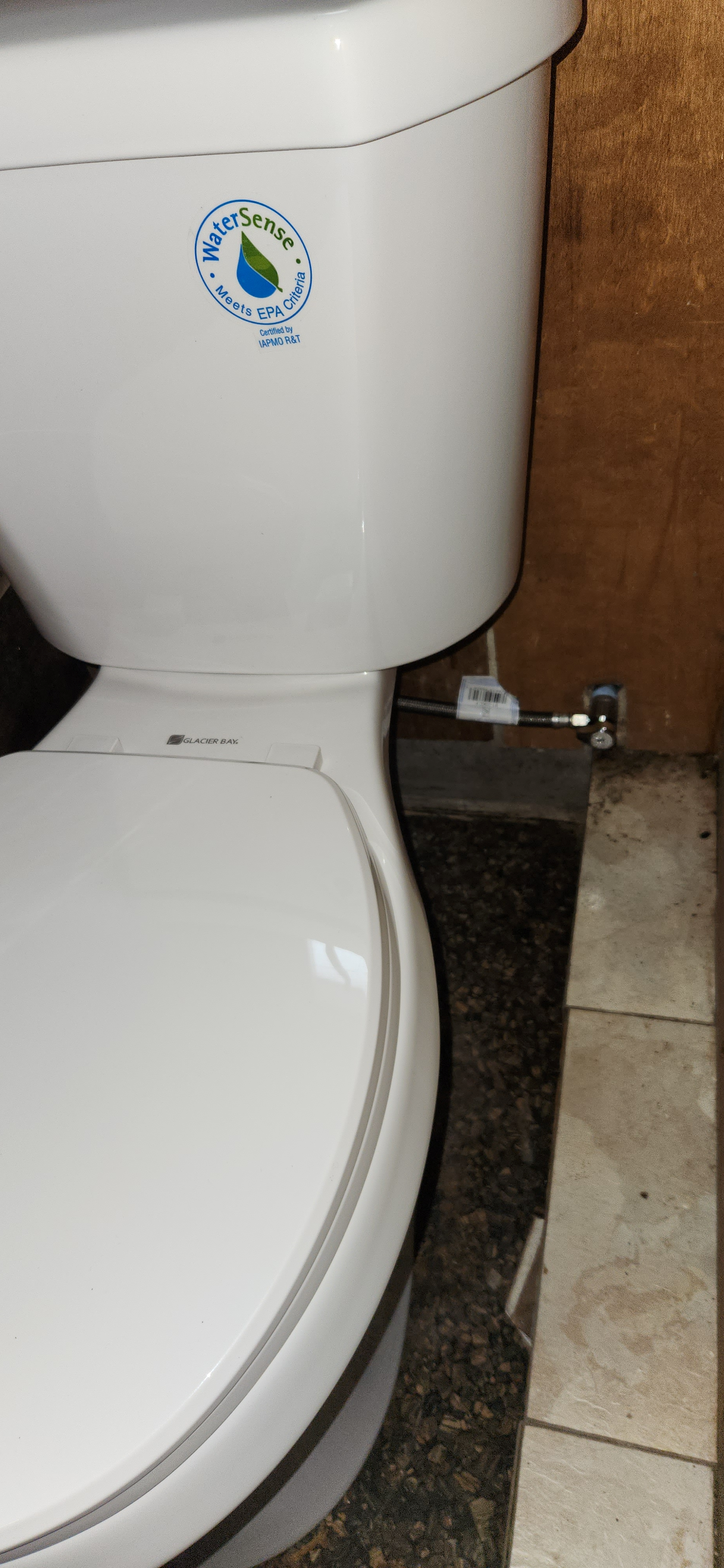 Close-up of a white Glacier Bay toilet with eco-friendly WaterSense label.