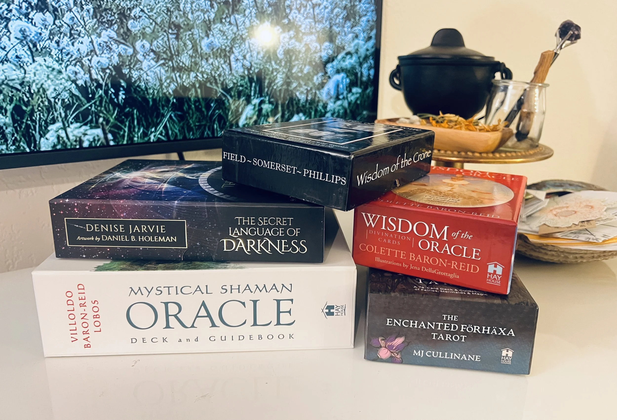 a stack of tarot and oracle card decks on a white surface