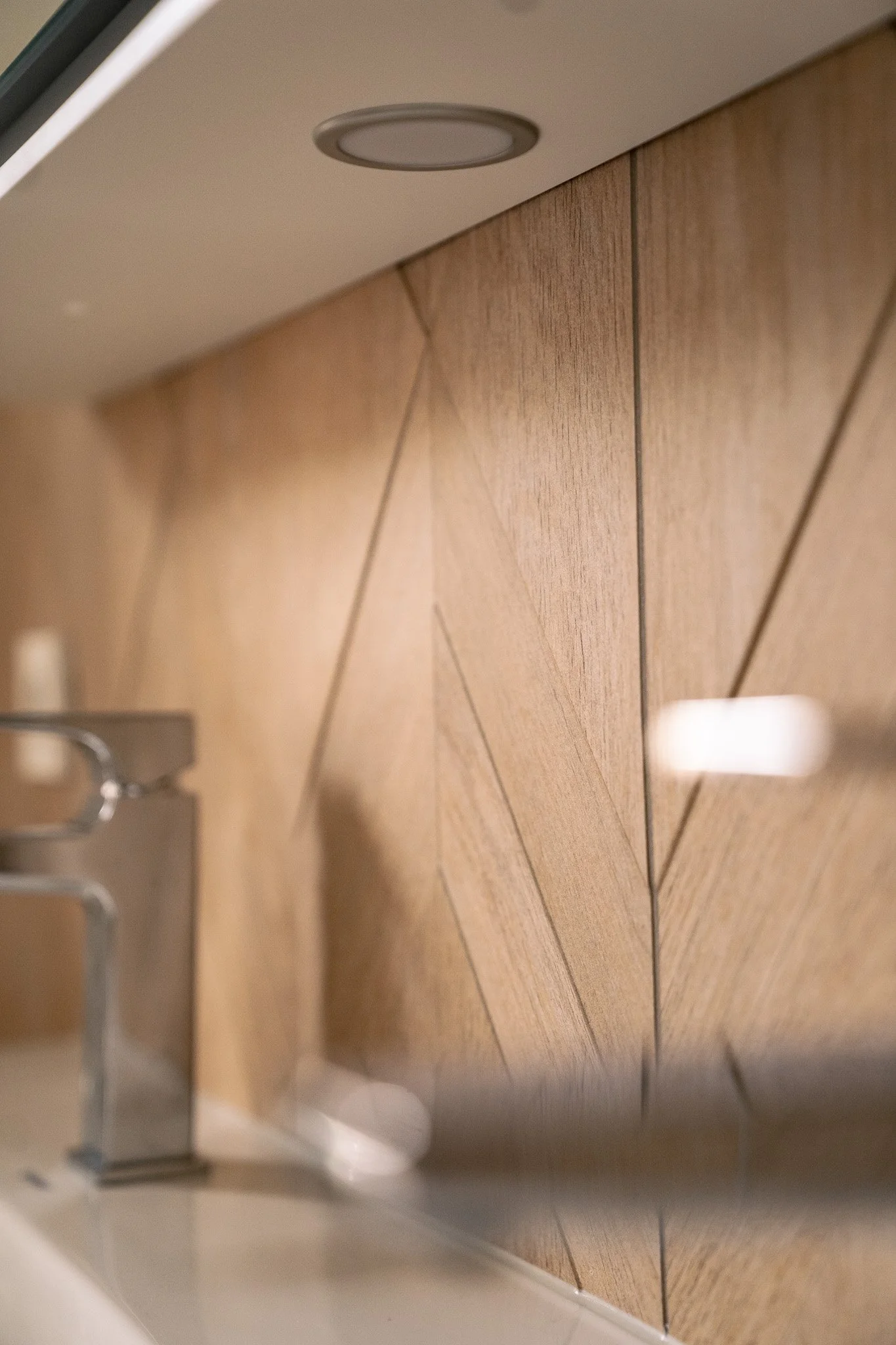 Nahaufnahme einer Wand mit braunen Fliesen und ein Teil eines Wasserhahns