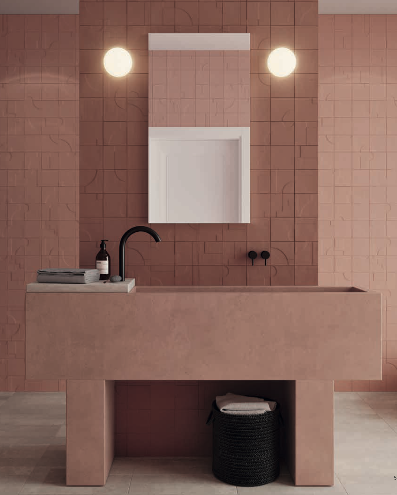 Ein modernes Badezimmer mit rosa Fliesen, einem weißen Waschbecken, schwarzem Wasserhahn, einem großen Wandspiegel, zwei runden Wandlampen, Ablage mit Handwaschmittel und Handtüchern, schwarzem Wäschekorb und Holzboden.