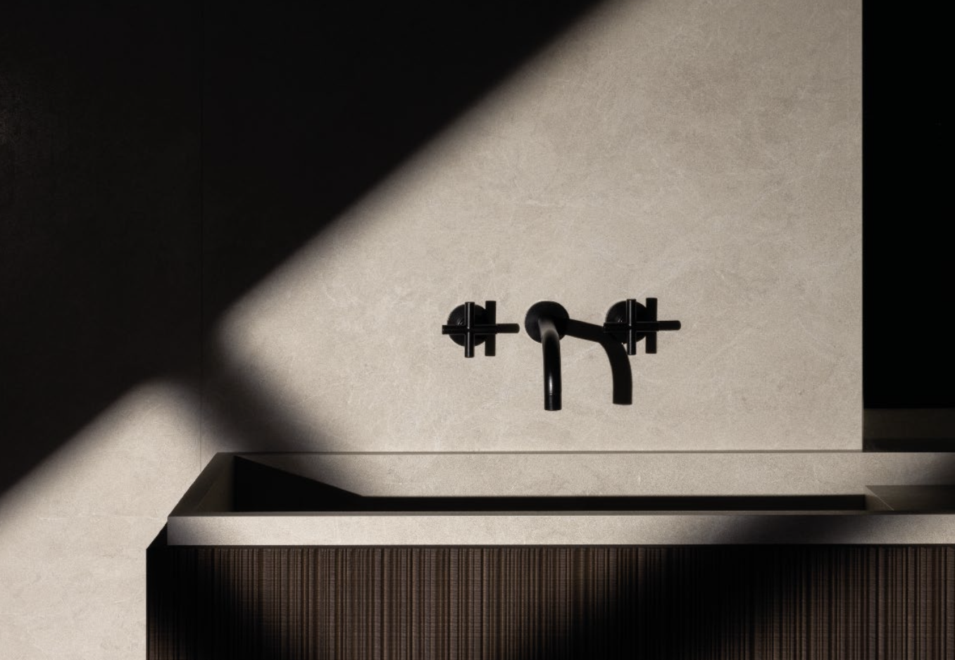 Schwarzfarbige Wasserhahn an einer hellen Wand mit dunklem Unterschrank