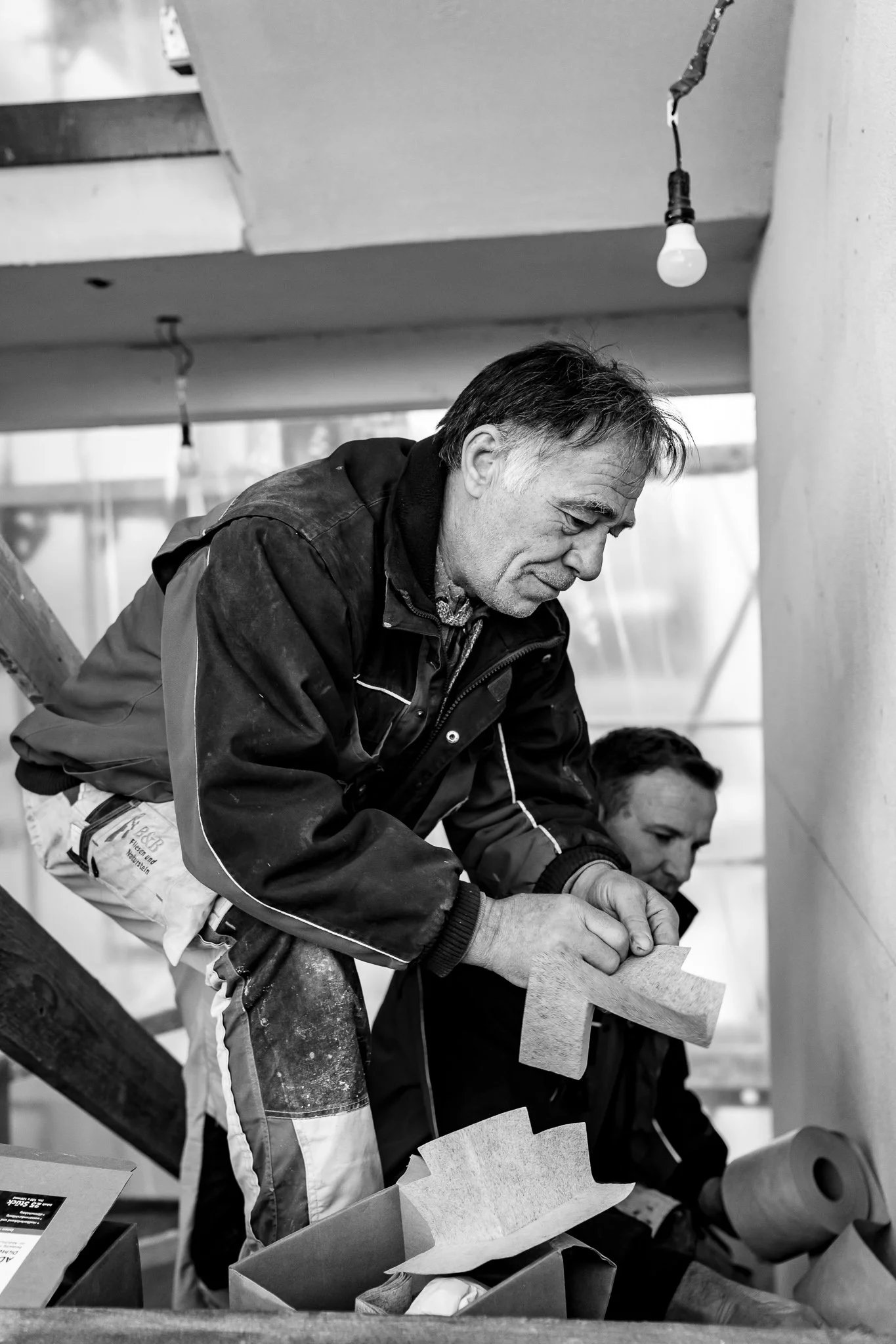 Zwei Männer bei der Holzbearbeitung in einer Werkstatt.