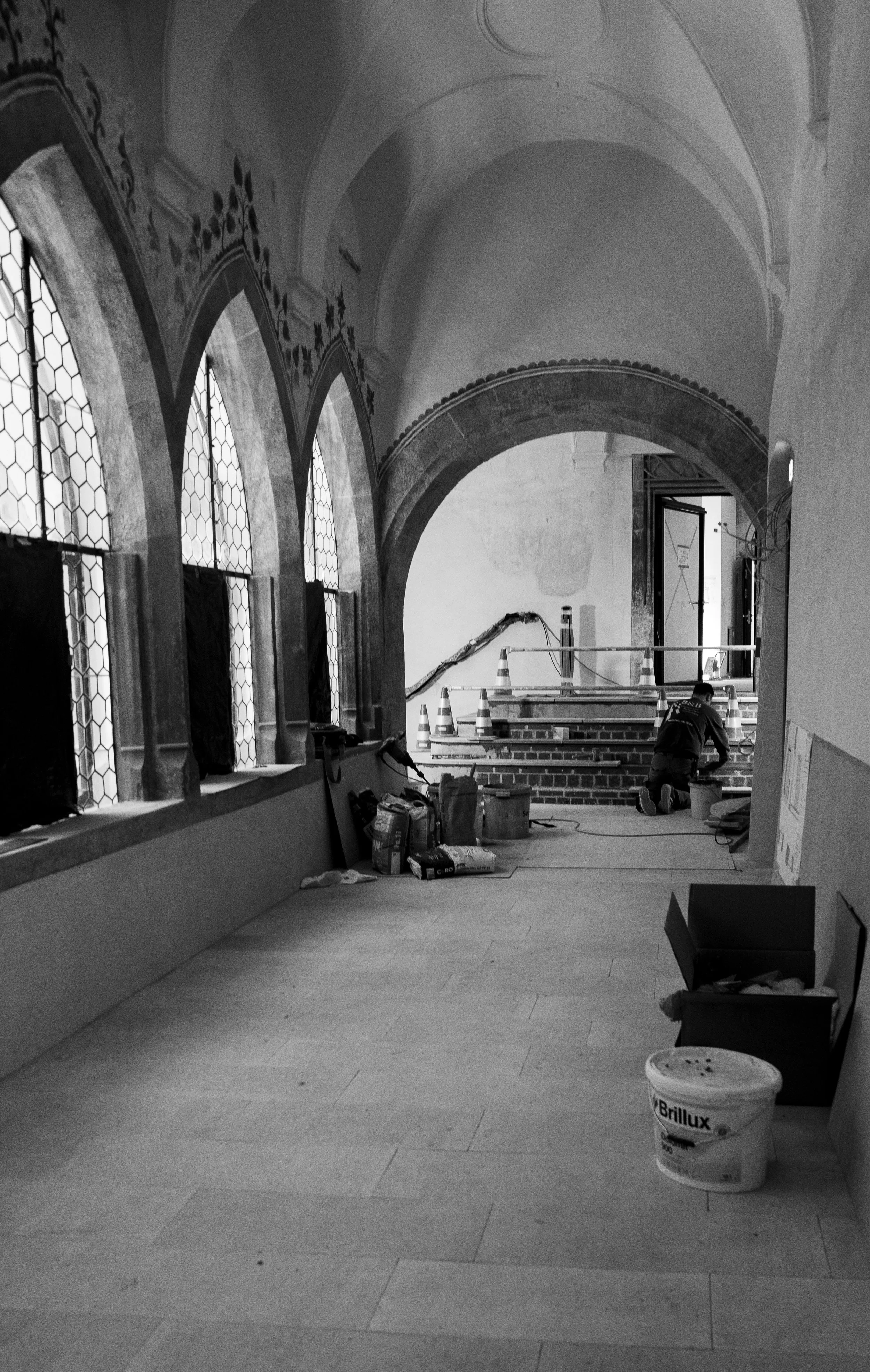 Innenaufnahme einer Kirche oder historischen Gebäude im Renovierungsprozess, mit Bauarbeitern, Baumaterialien und Gerüsten.