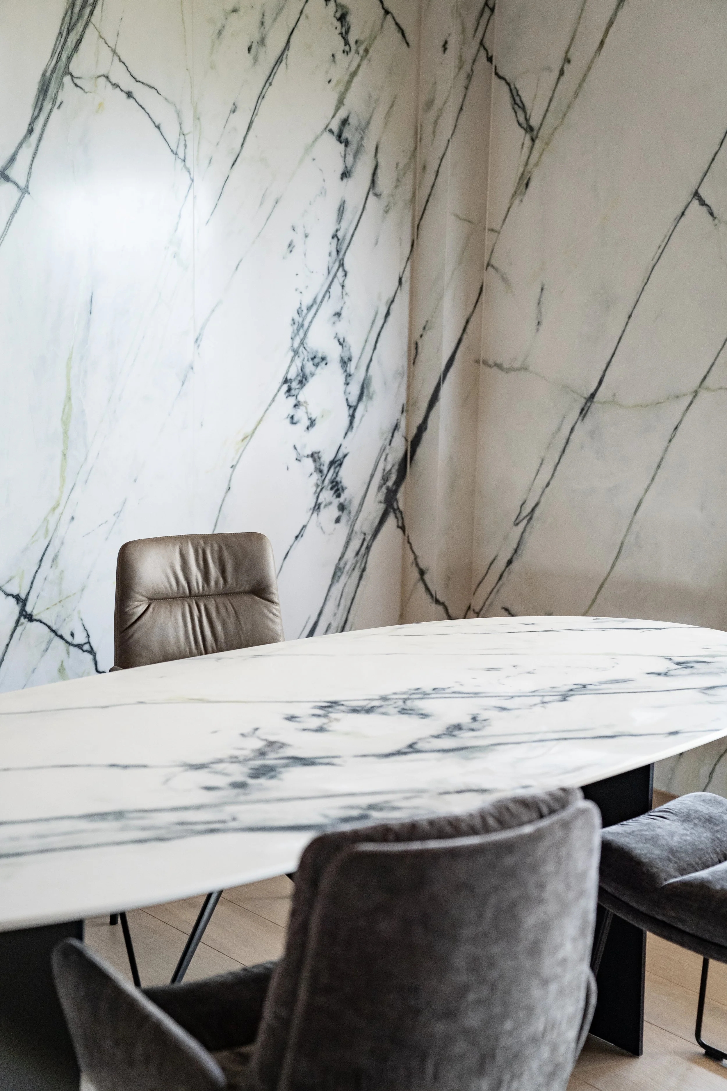 Ein eleganter Konferenztisch aus weißem Marmor in einem modernen Meetingraum, umgeben von gepolsterten Stühlen.