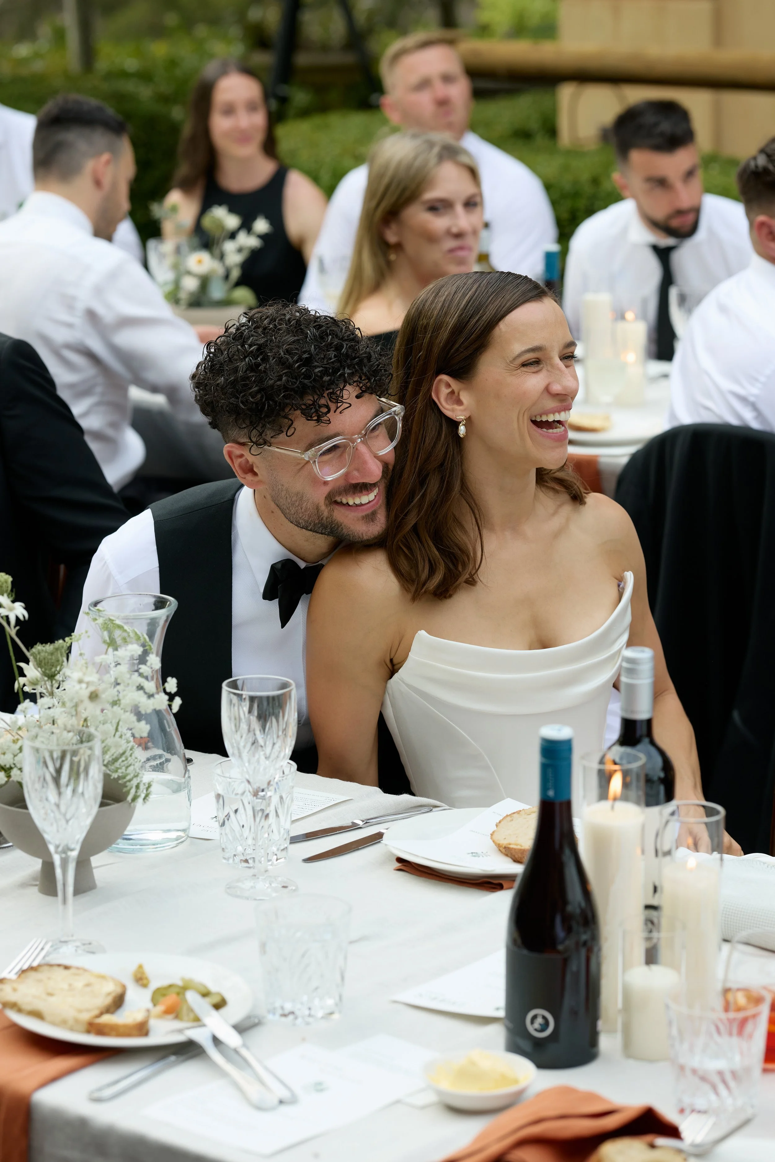 A newly married couple at their wedding reception with the grooms chin on the brides shoulder