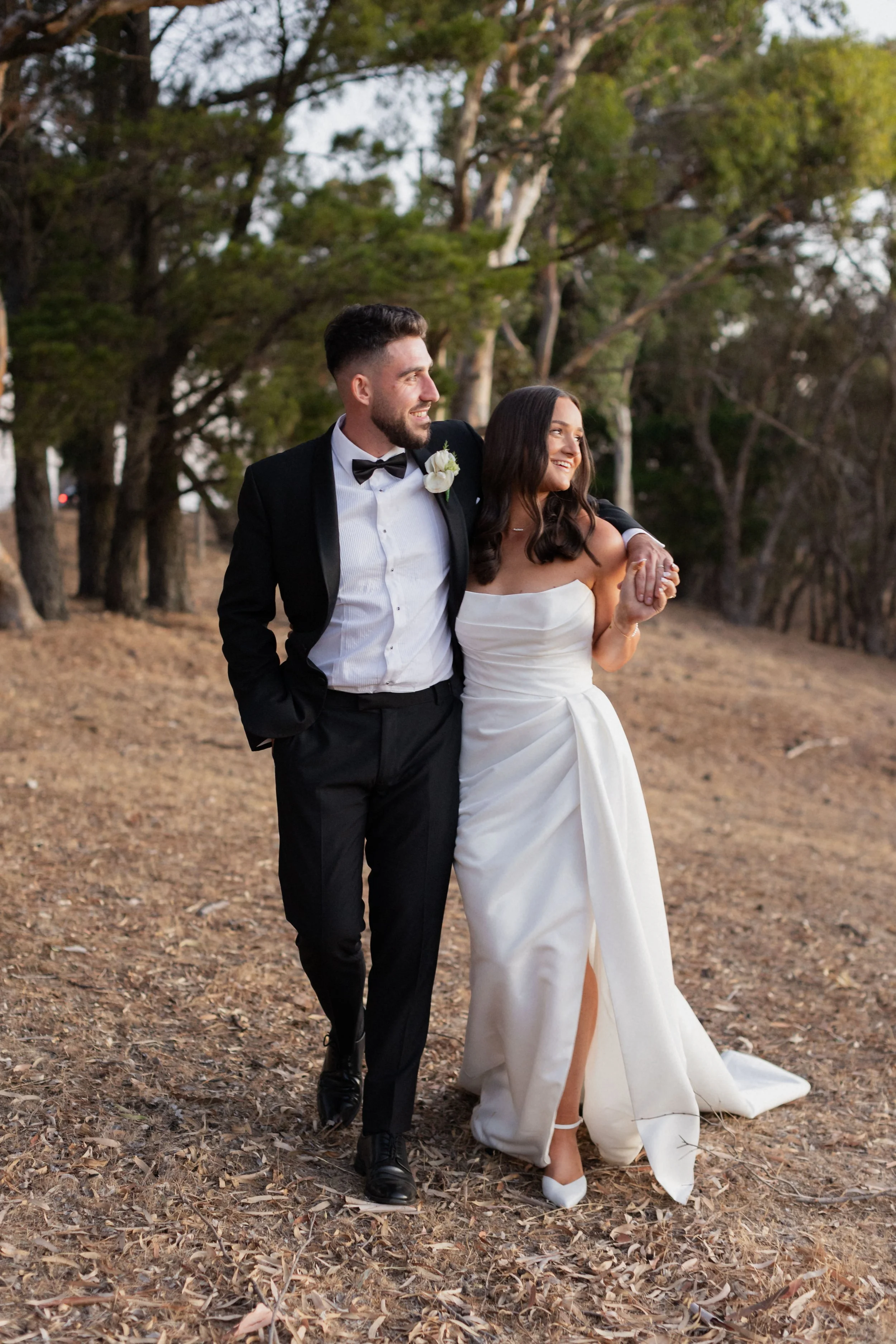A newly married couple standing in a forest