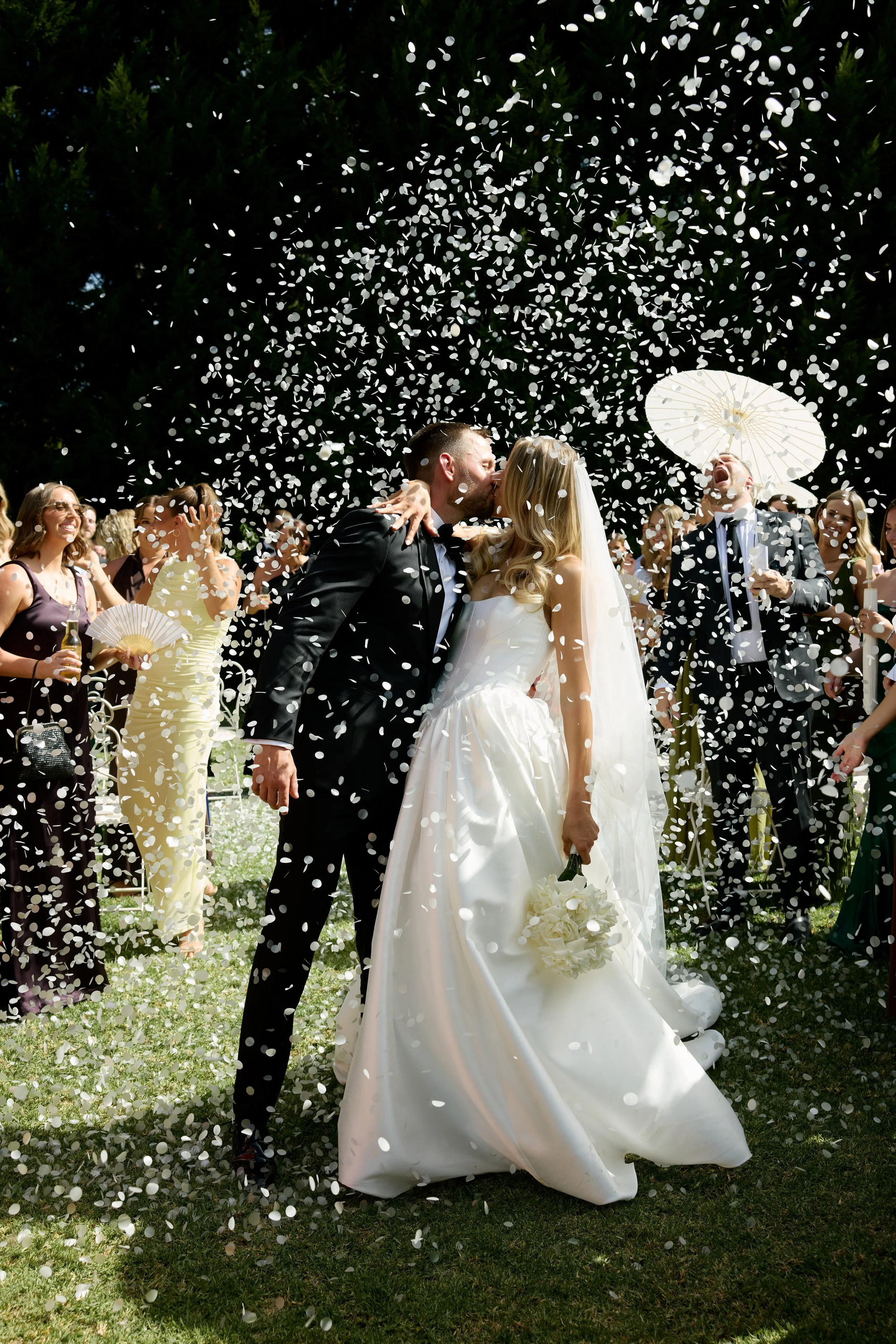 A newly married couple at their wedding showered in confetti