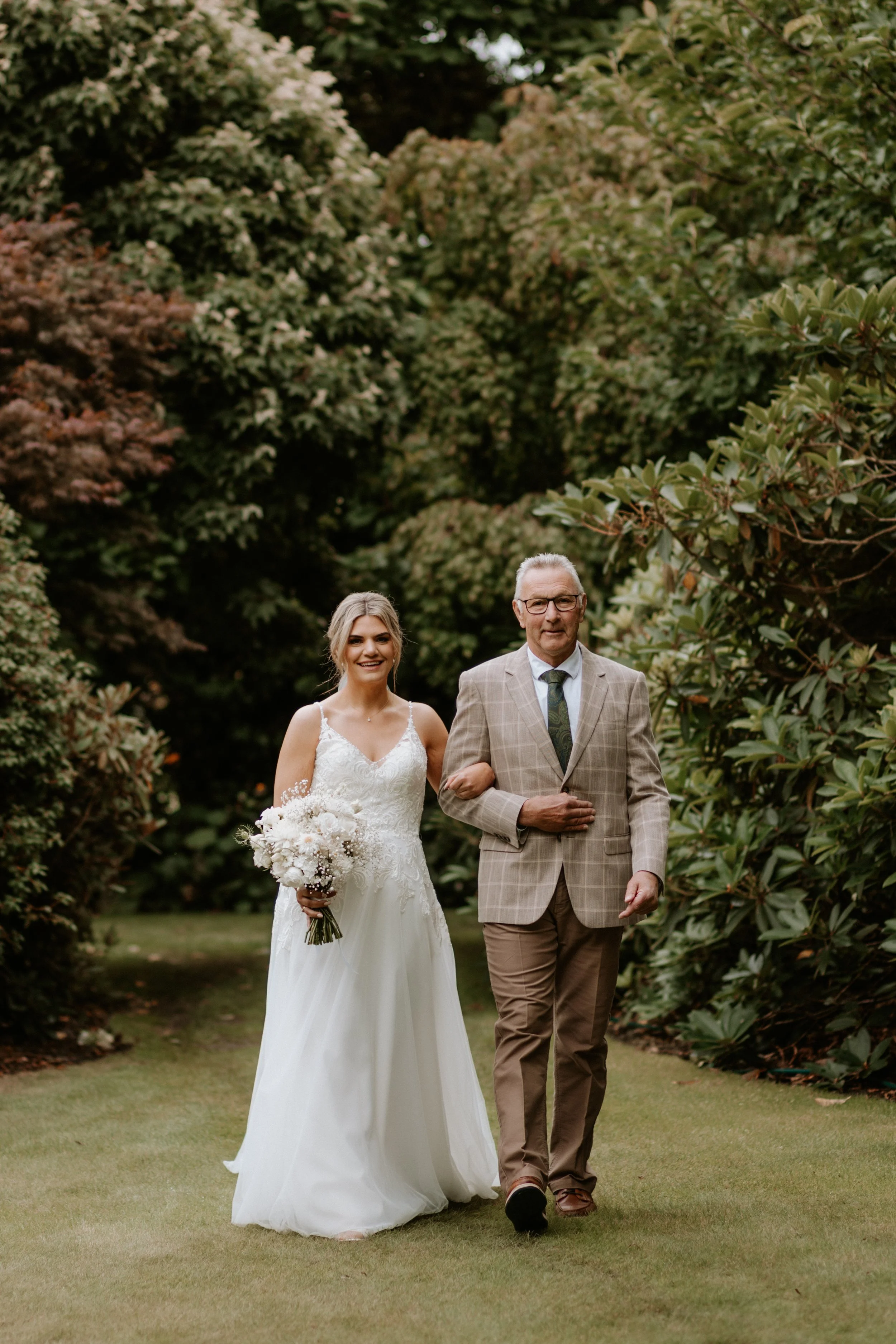 father and bride walking and smiling