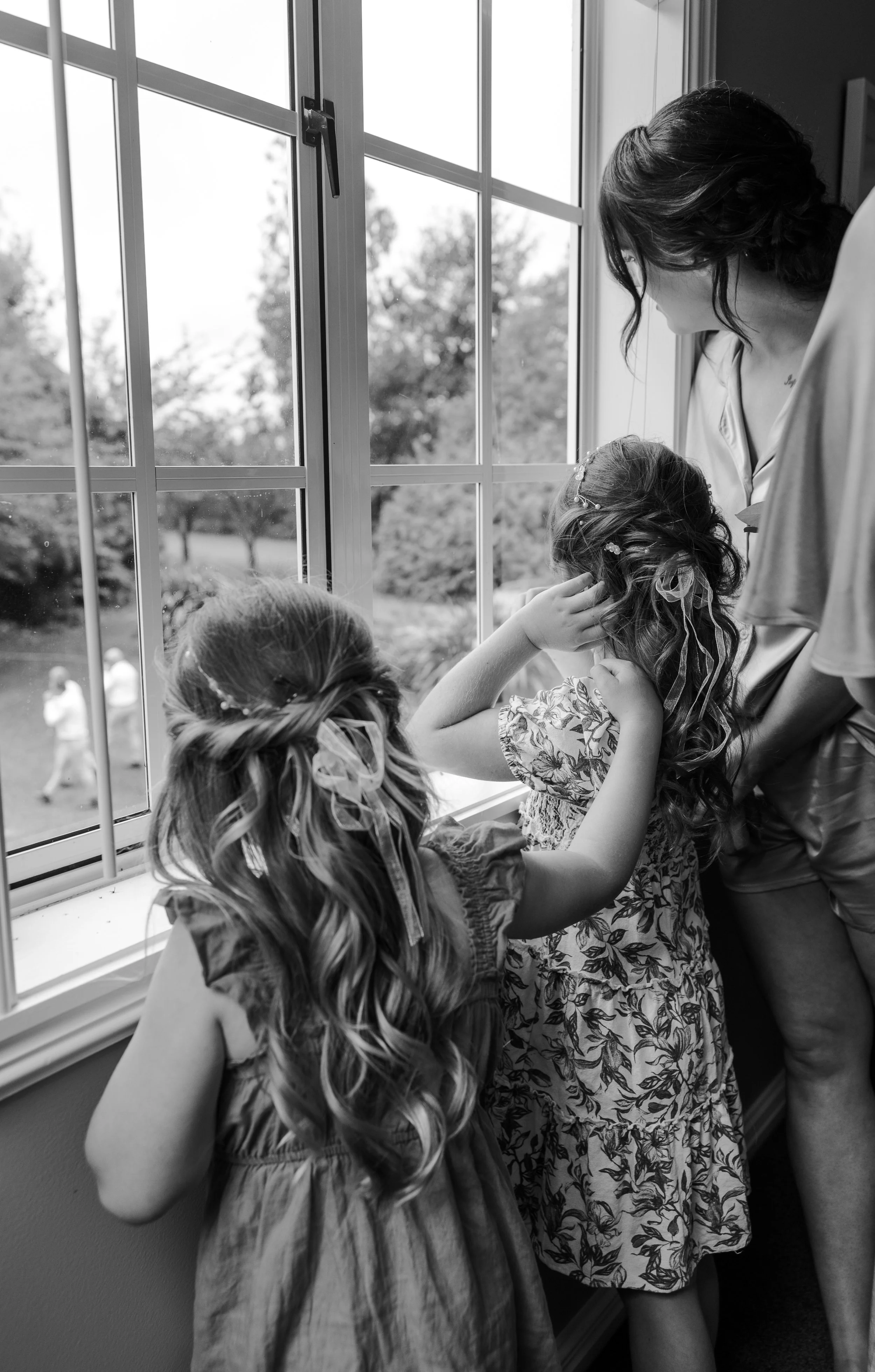 kids looking out window at dad