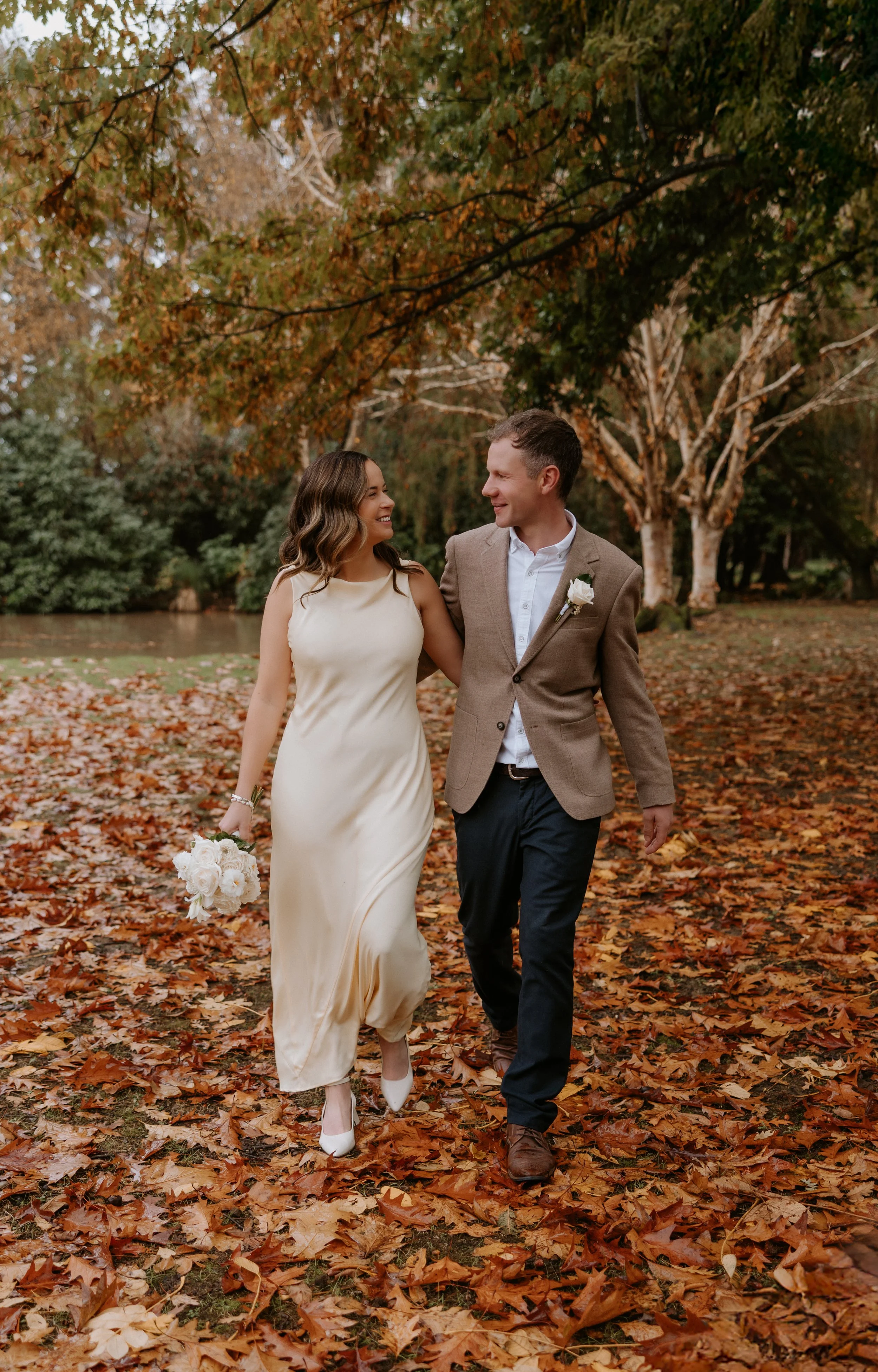 bride and groom walking smiling at each other