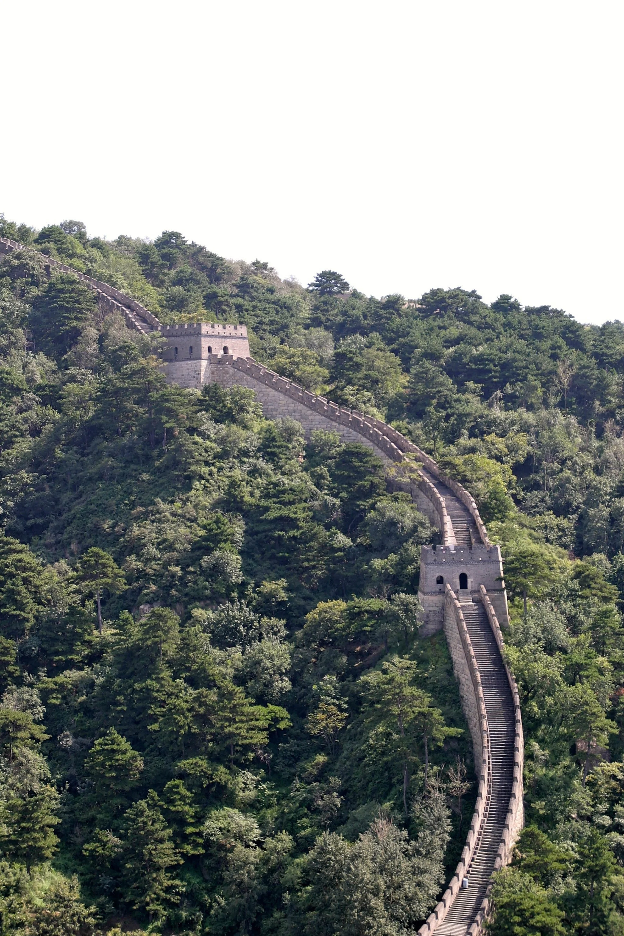 The Great Wall of China winding through lush green mountains.