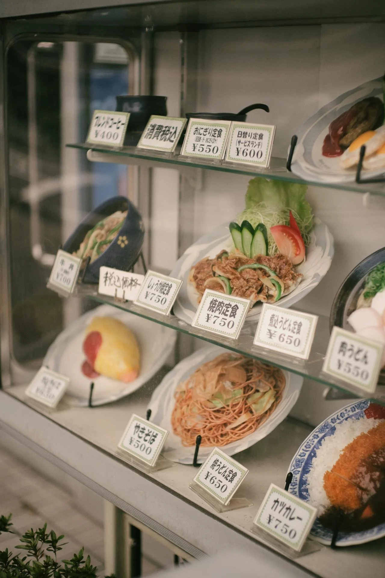 Faded plastic food sample display case outside an old Japanese restaurant, a classic sign of a Dirty Michelin spot