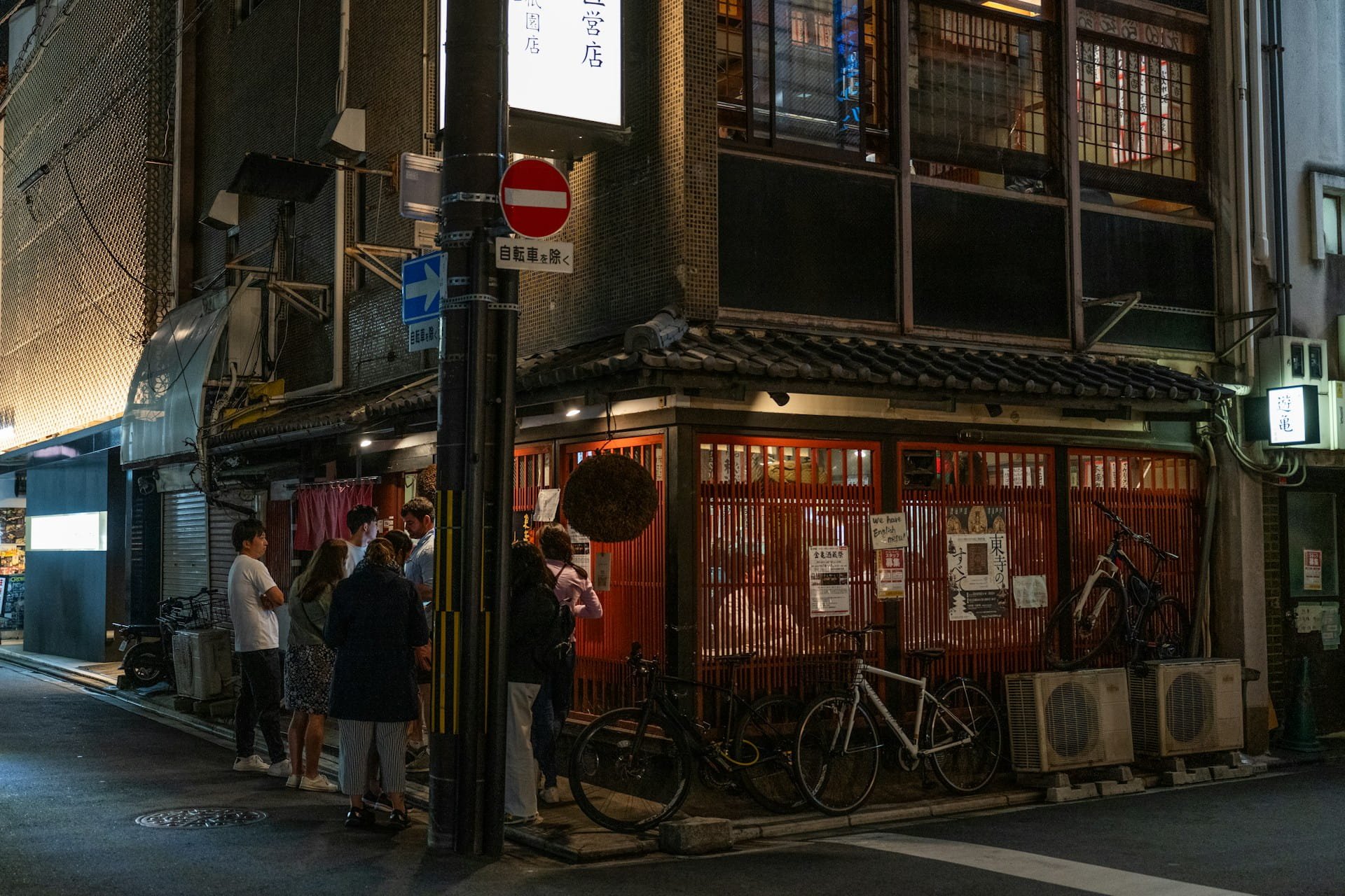 Queue of diners waiting outside a traditional Japanese restaurant at night, Kyoto