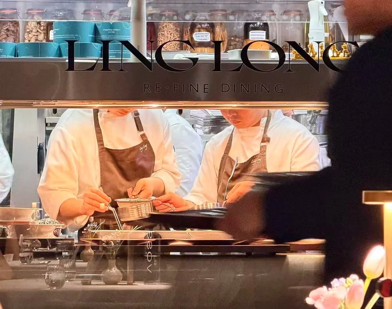 Chefs at work in the open kitchen of Ling Long Re-Fine Dining, viewed through the pass