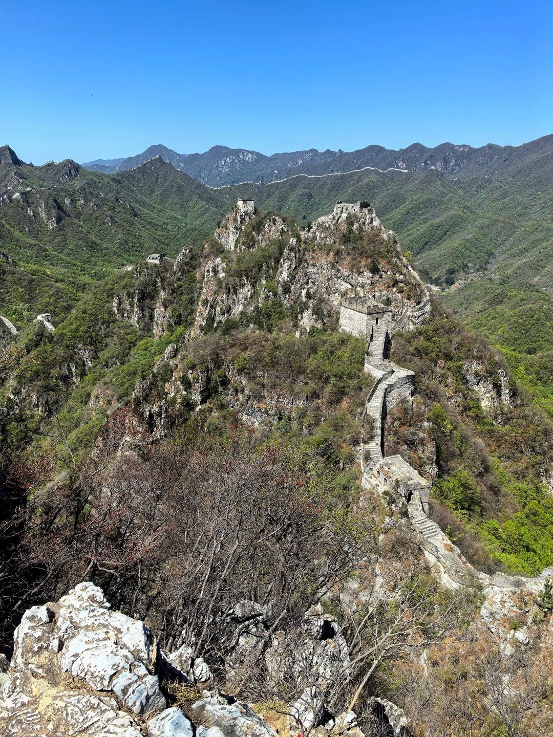 Jiankou Great Wall snaking across dramatic rocky peaks near Beijing, watchtowers visible on multiple summits stretching into the far distance
