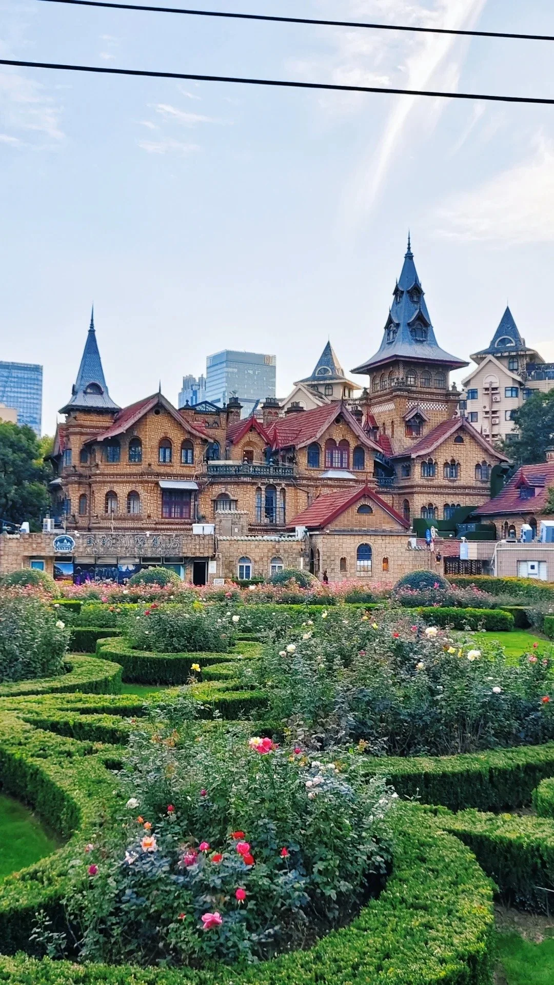 The Moller Villa hotel in Shanghai, with turreted roofs, above a landscaped flower garden