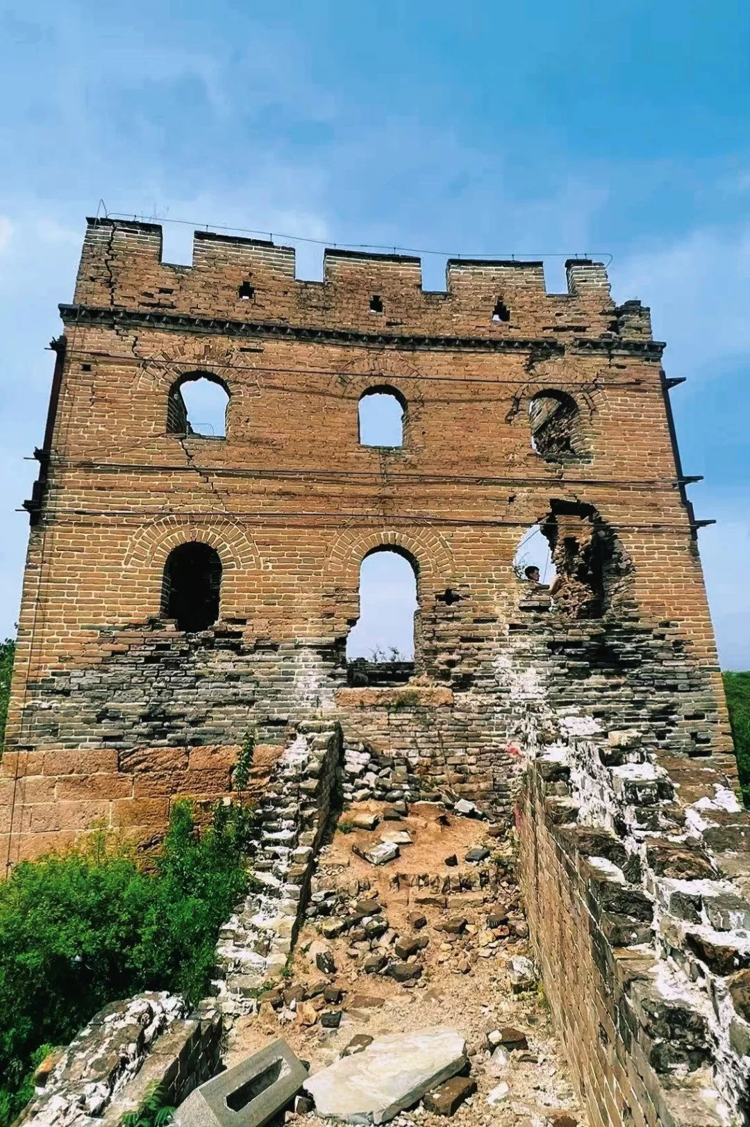 Heavily deteriorated unrestored watchtower at Gubeikou Great Wall, crumbling brickwork and missing sections showing 500 years of weathering, Beijing