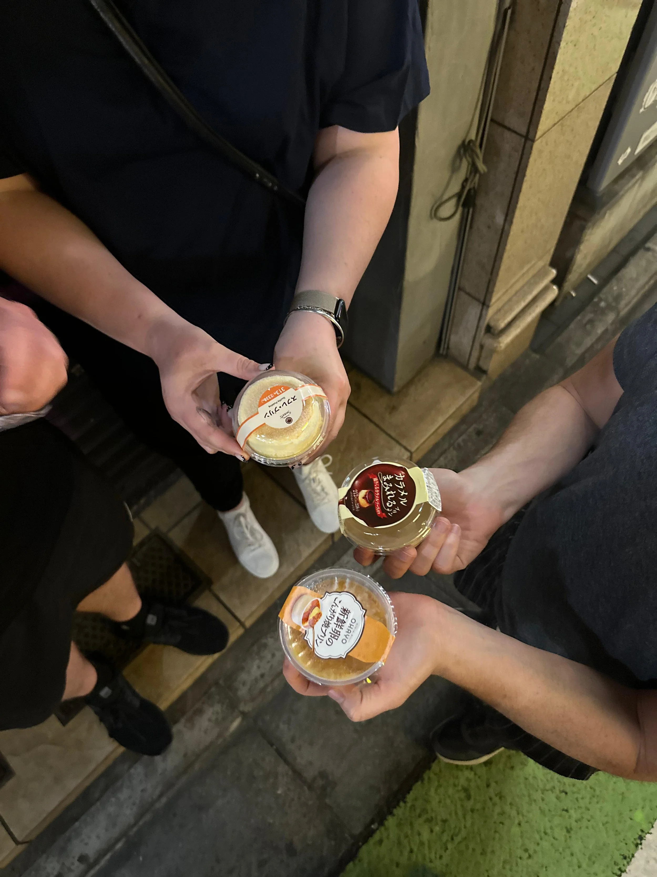 People holding purin outside on a street ready for a taste test