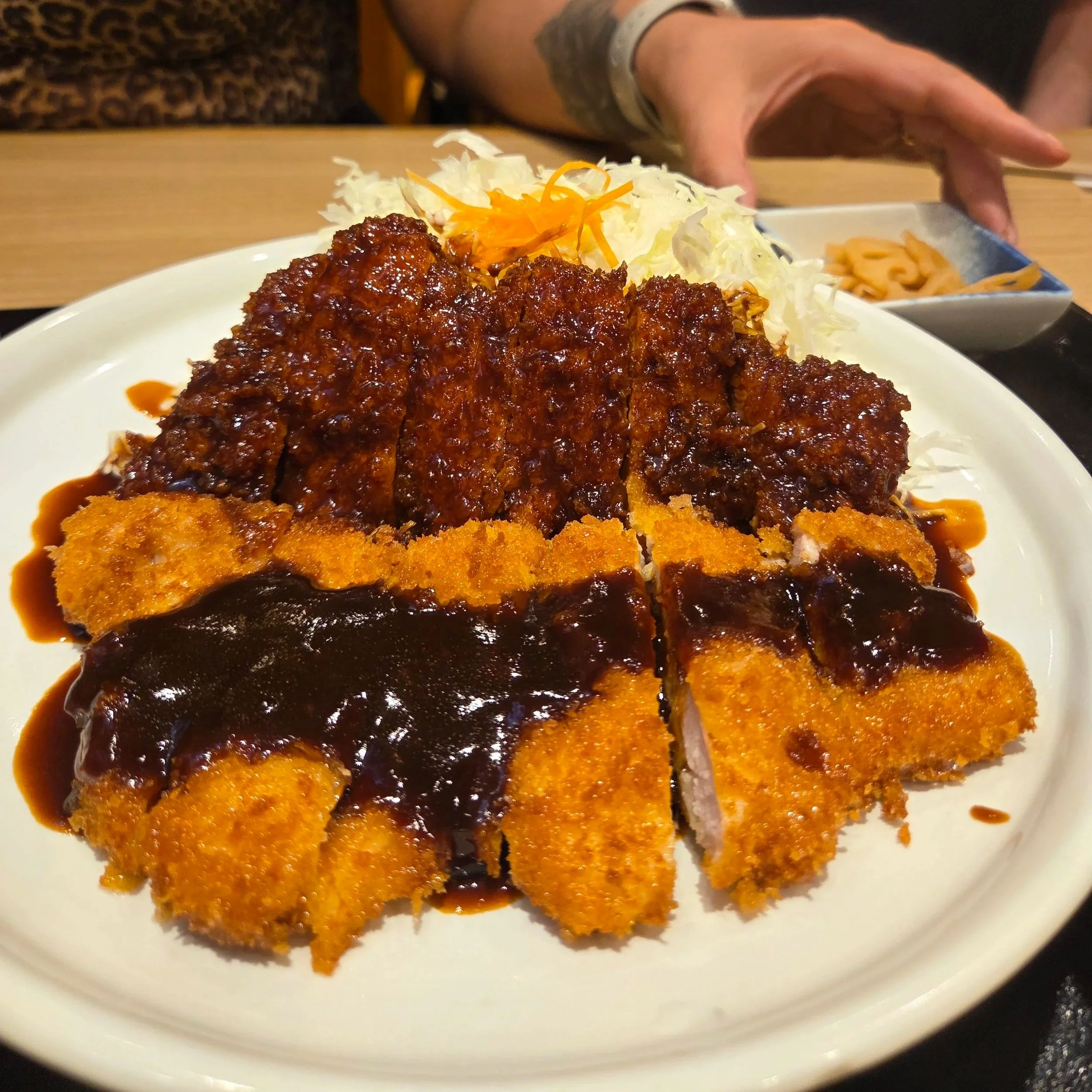 Two portions of miso katsu in Nagoya, one coated in hatcho miso, the other with miso poured on top after serving