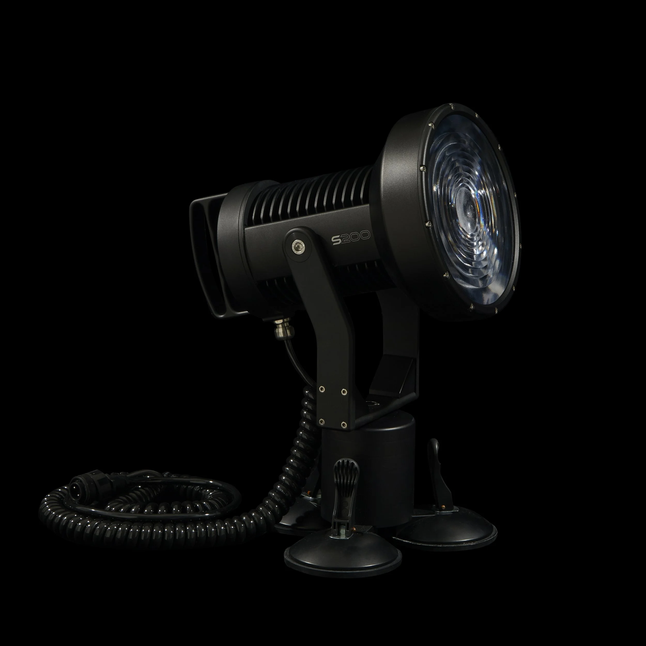 Black spotlight with a coiled power cable against a black background.