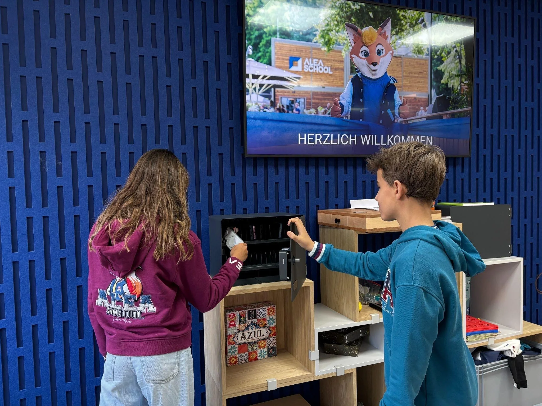 Schülerinnen und Schüler legen morgens ihre Smartphones in Handygaragen an der ALEA SCHOOL ab