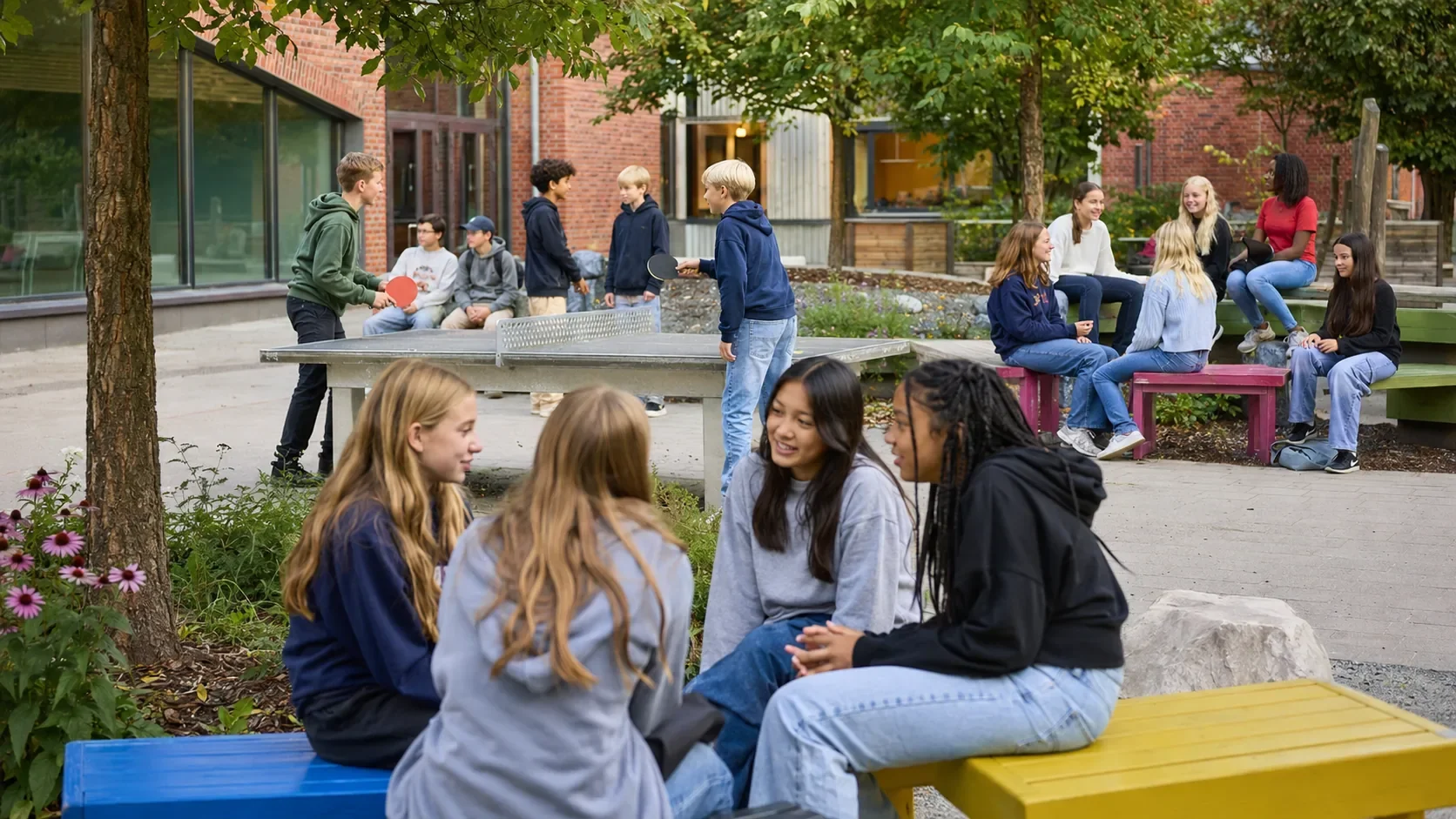Jugendliche unterhalten sich und spielen Tischtennis auf dem Schulhof einer schwedischen Schule während einer smartphonefreien Pause.