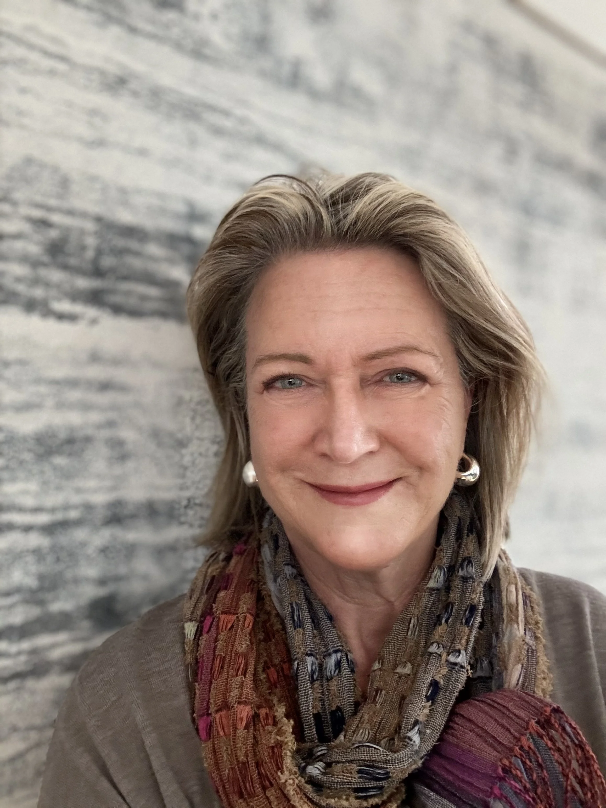 Portrait of the artist Rebecca Battman, in her Cotswold studio, standing in front of one of her own large abstract paintings.