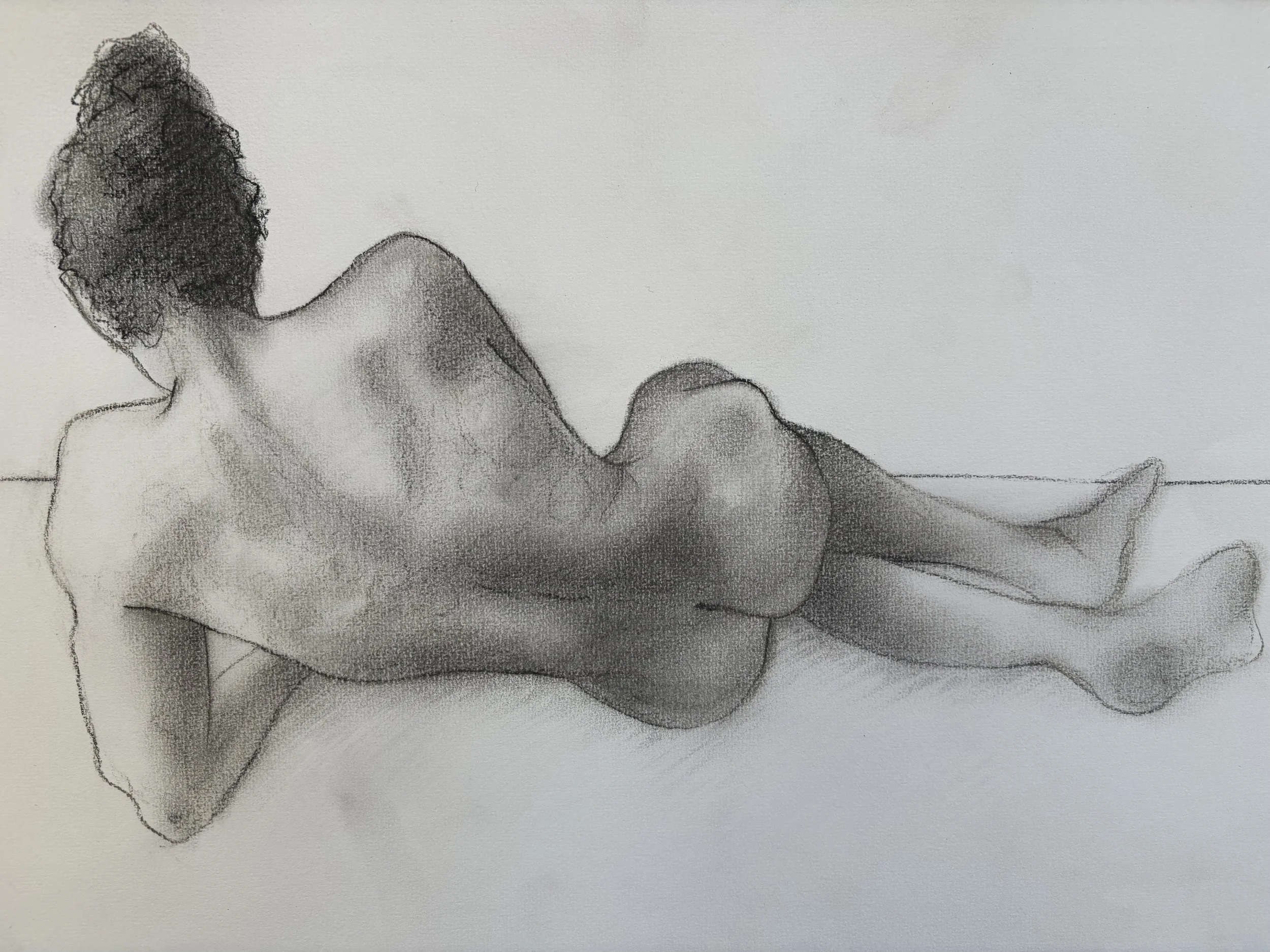 A black-and-white drawing of a reclining nude man with curly hair, lying on his side on a flat surface.