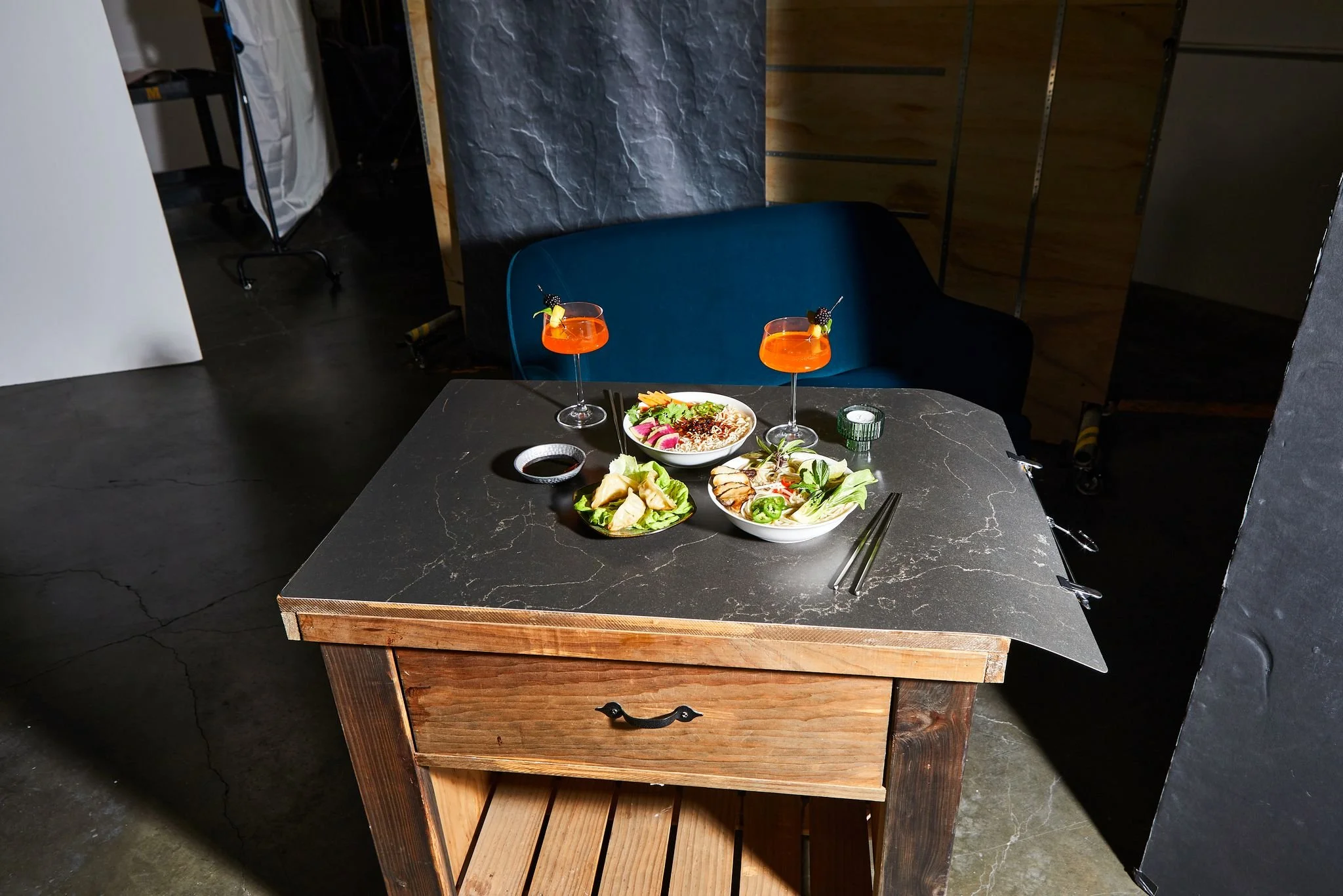 A table set with salads and two cocktails, in a modern restaurant or cafe.