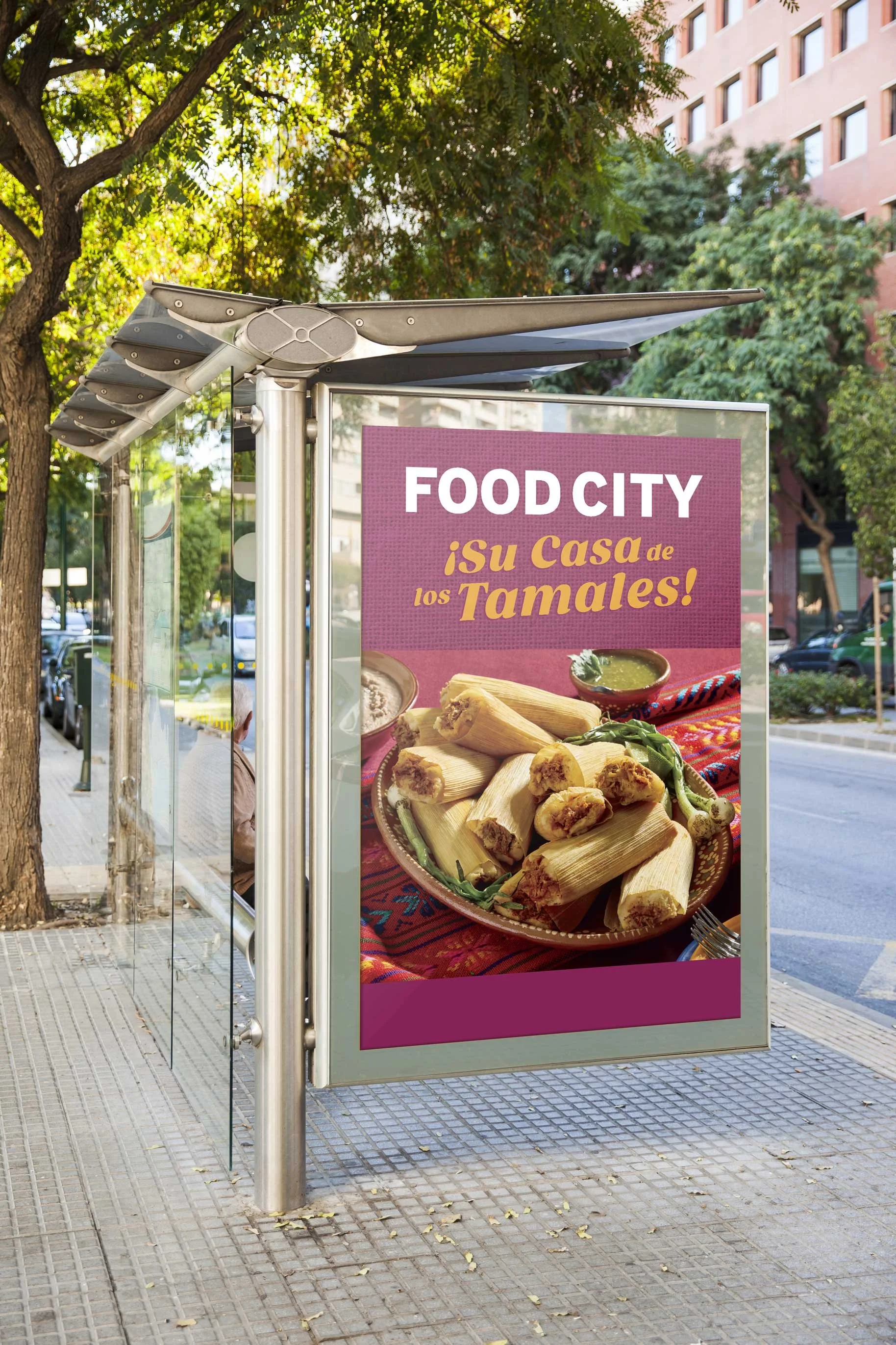 Bus stop advertisement for Food City featuring an image of plate of tamales with salsa and green peppers, with text in Spanish and English.