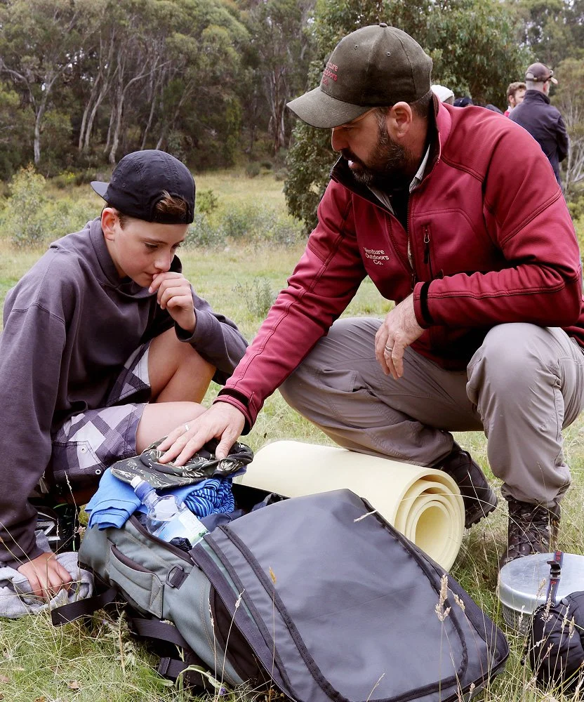 Instructor assisting a student with packing outdoor equipment on a Venture Outdoors Co. program.