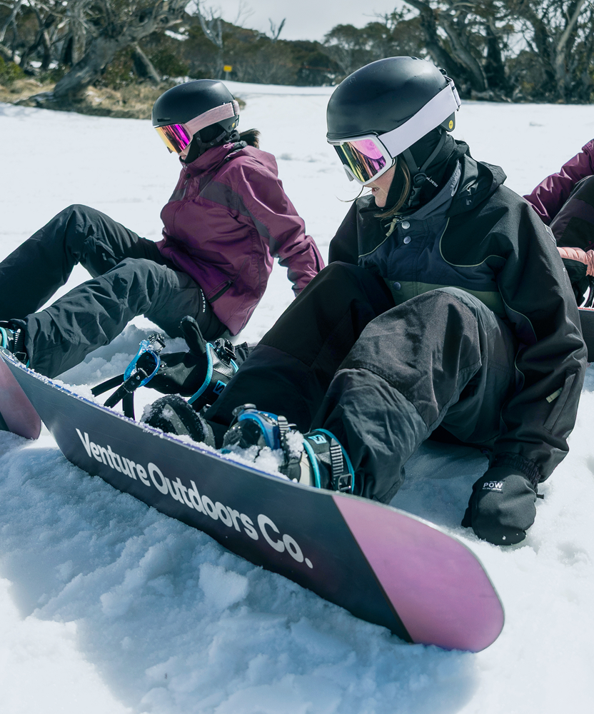 Students sitting on snowboards during a Venture Outdoors Co. winter activity.