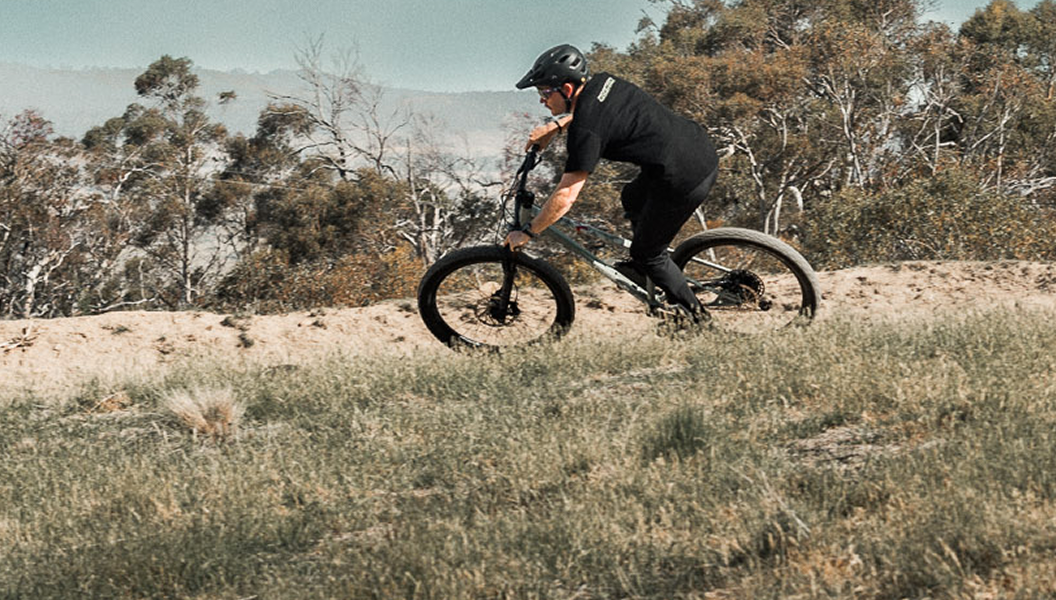 Mountain biker riding a trail in the Snowy Mountains featuring Venture Outdoors Co. bike hire.
