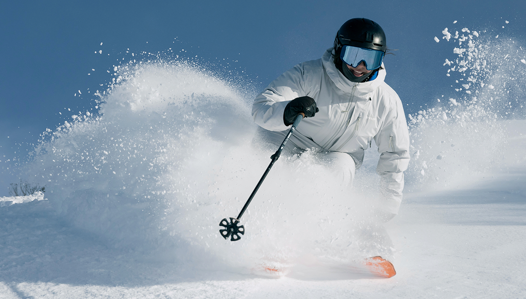 Skier carving through fresh snow showcasing Venture Outdoors Co. ski and snowboard hire equipment.