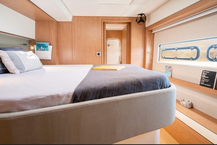 Chambre moderne avec lit à baldaquin, fenêtres ovales, murs en bois, et décoration minimaliste