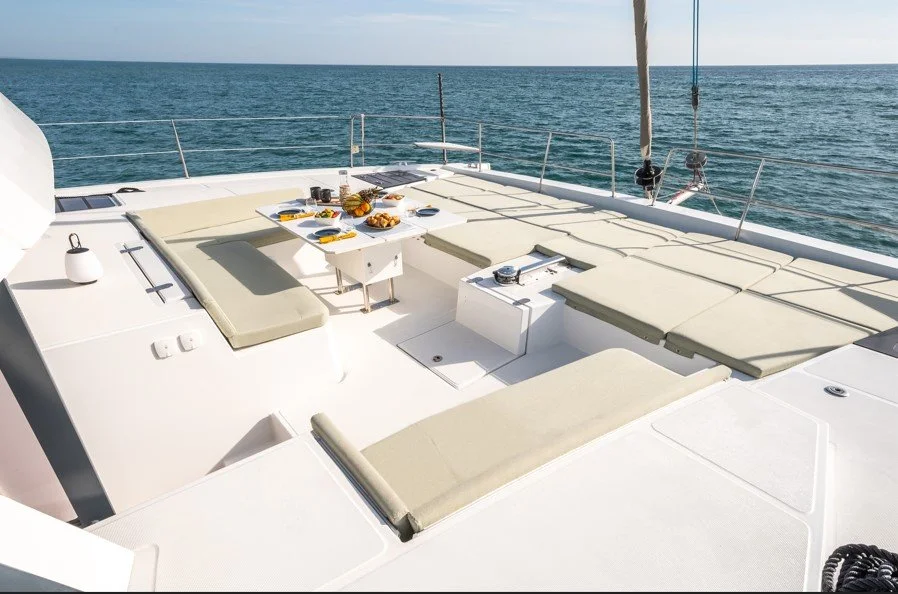 Une vue du pont d'un yacht avec des coussins confortables, une table avec des plats et des boissons, en mer par beau temps