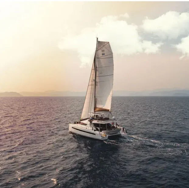 Un voilier naviguant en mer lors du coucher du soleil.