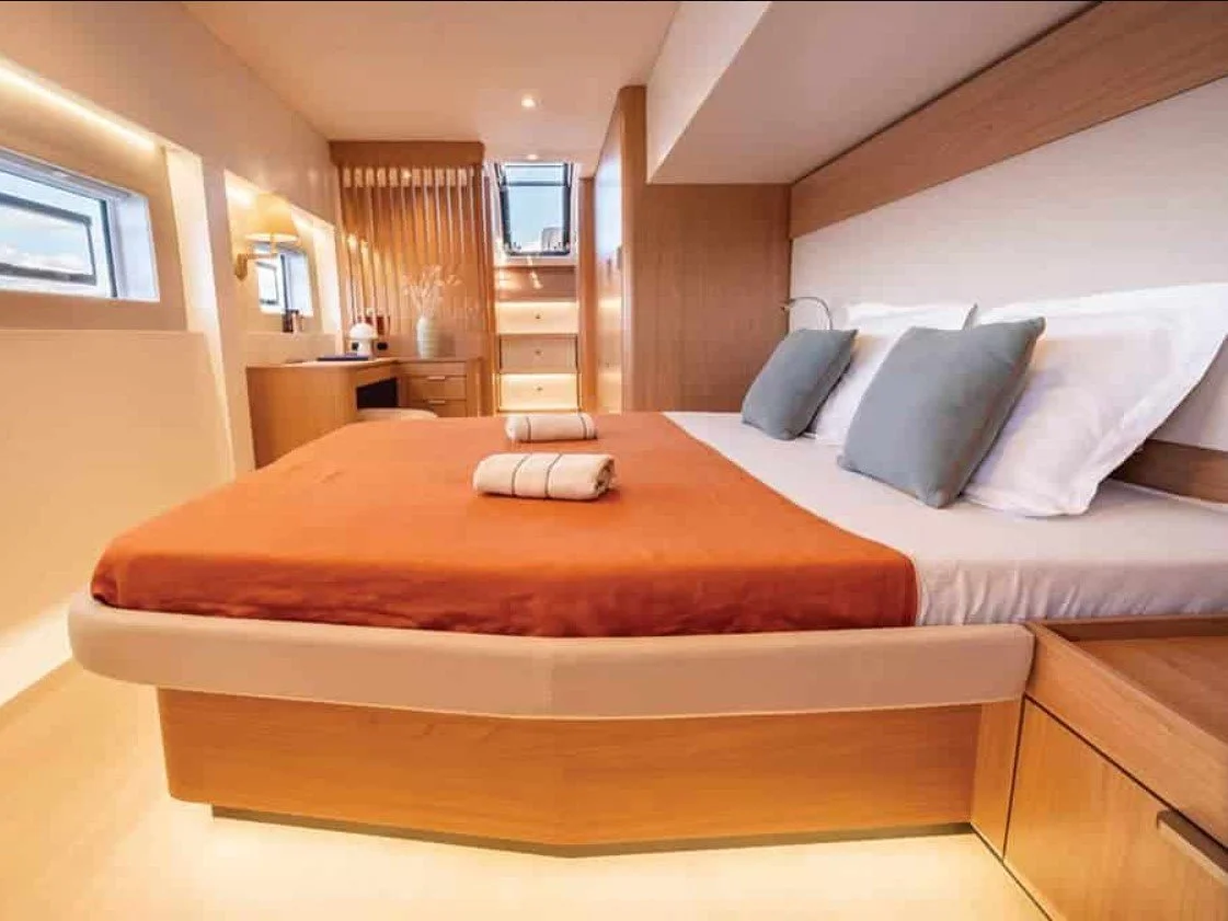 Chambre double avec lit king-size, draps blancs, oreillers gris, rideaux en bois, petites fenêtres, meubles en bois, lampes de lecture, décoration moderne.