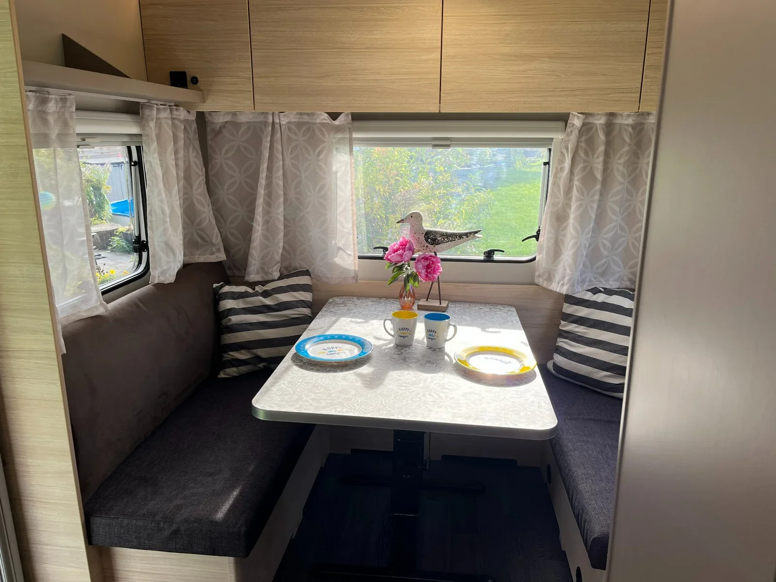 Gemütliche Sitzgruppe mit Tisch und Fenstern im Weinsberg CaraCito 470 EU (2021) – Standort Oberkrämer.